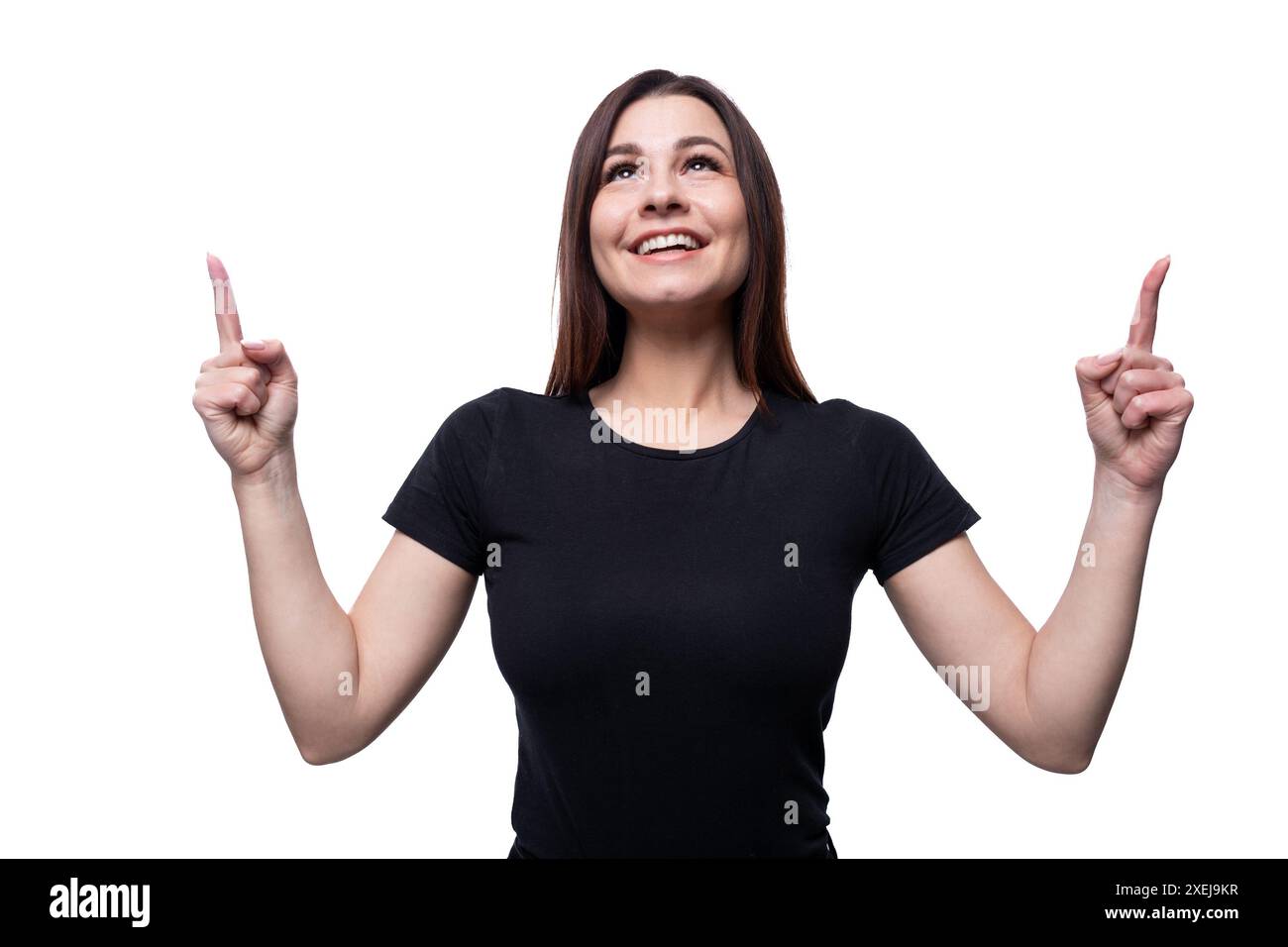 Eine junge selbstbewusste Frau mit schwarzen Haaren in einem schwarzen T-Shirt zeigt ihre Hände hoch Stockfoto