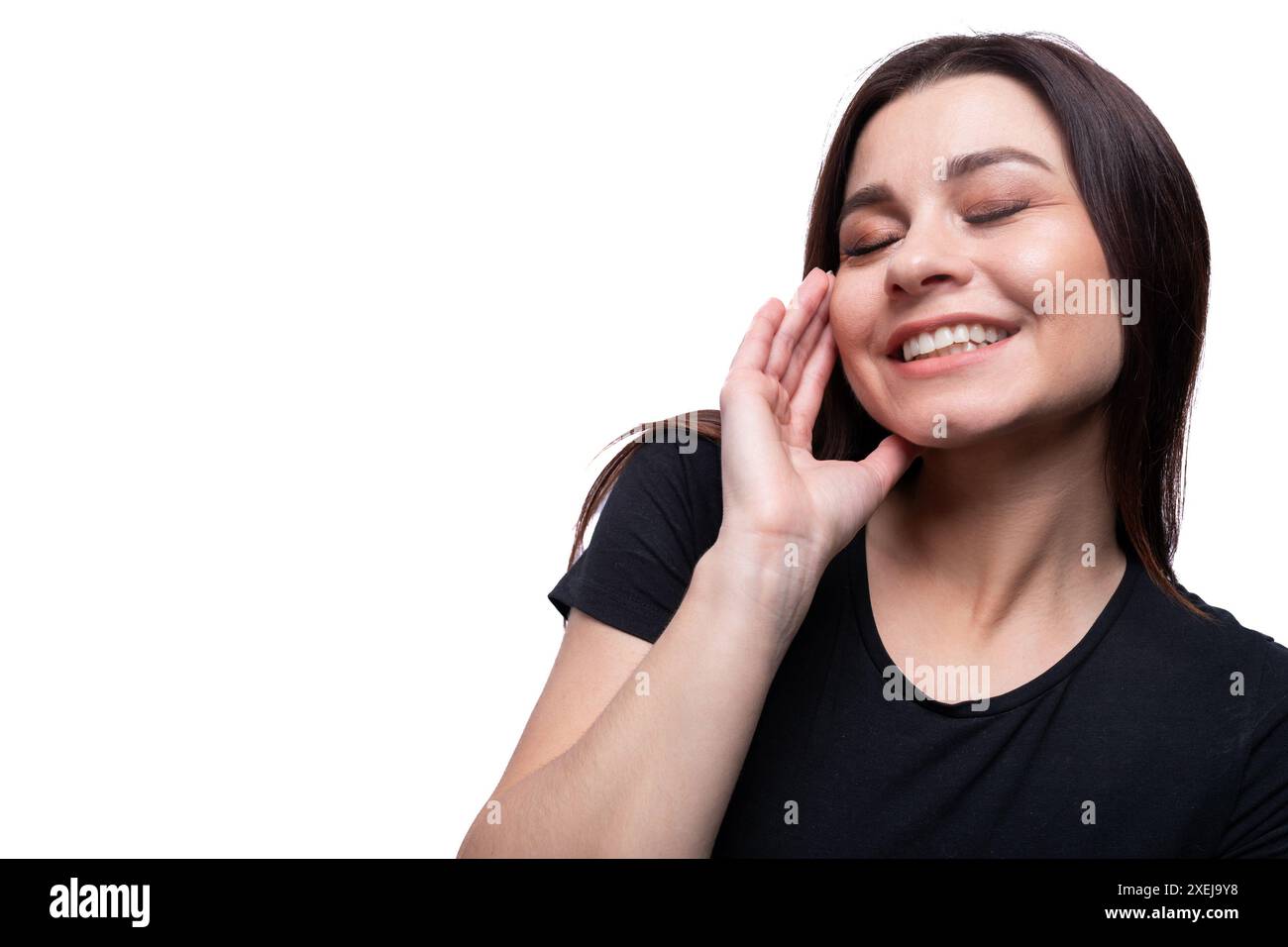 Kaukasische junge freundliche Brünette, die ein schwarzes T-Shirt auf weißem Hintergrund trägt Stockfoto