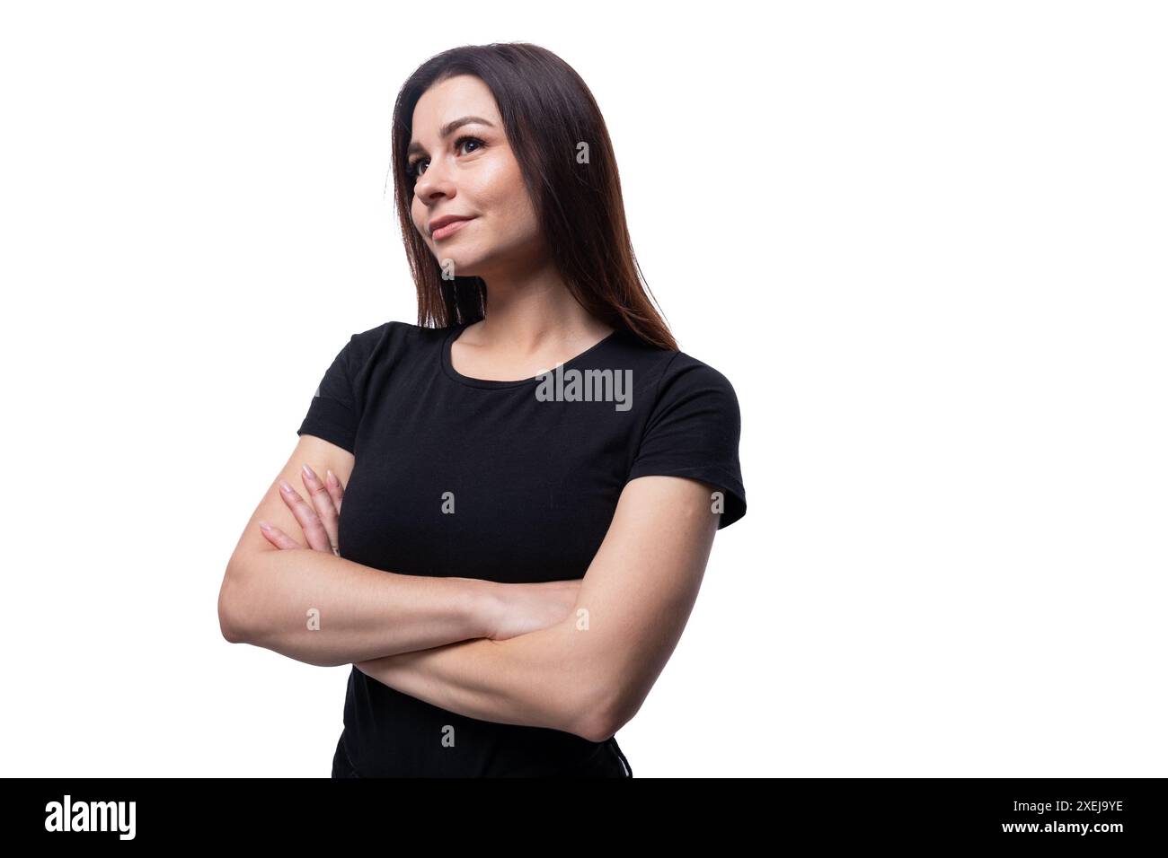 Selbstbewusste schöne junge brünette Frau in schwarzem T-Shirt auf weißem sauberem Hintergrund Stockfoto