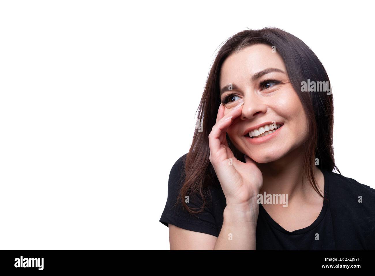 Junge bescheidene Frau mit braunen Augen, die ein schwarzes T-Shirt auf einem Hintergrund mit Kopierraum trägt Stockfoto