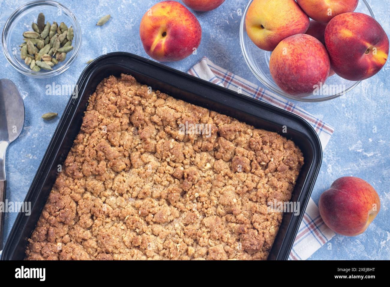 Köstlicher Peach Crisp oder Schuster mit braunem Zucker, Kardamom und Haferstreusel in einer Unterschale, horizontal, Draufsicht Stockfoto