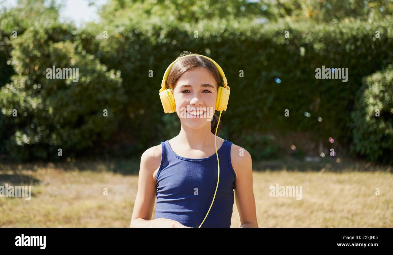 Mädchen, das Musik im Park hört Stockfoto