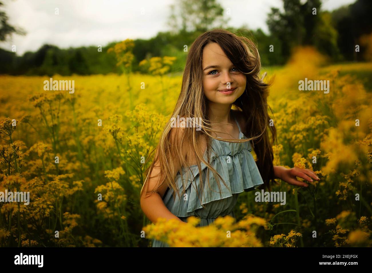 Nahaufnahme schönes Mädchen, das auf gelbem Blumenfeld tanzt Stockfoto