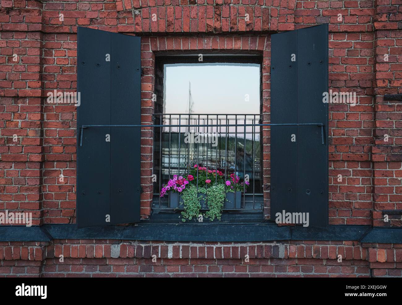 Fenster mit schwarzen Fensterläden und Sommerblumen Stockfoto
