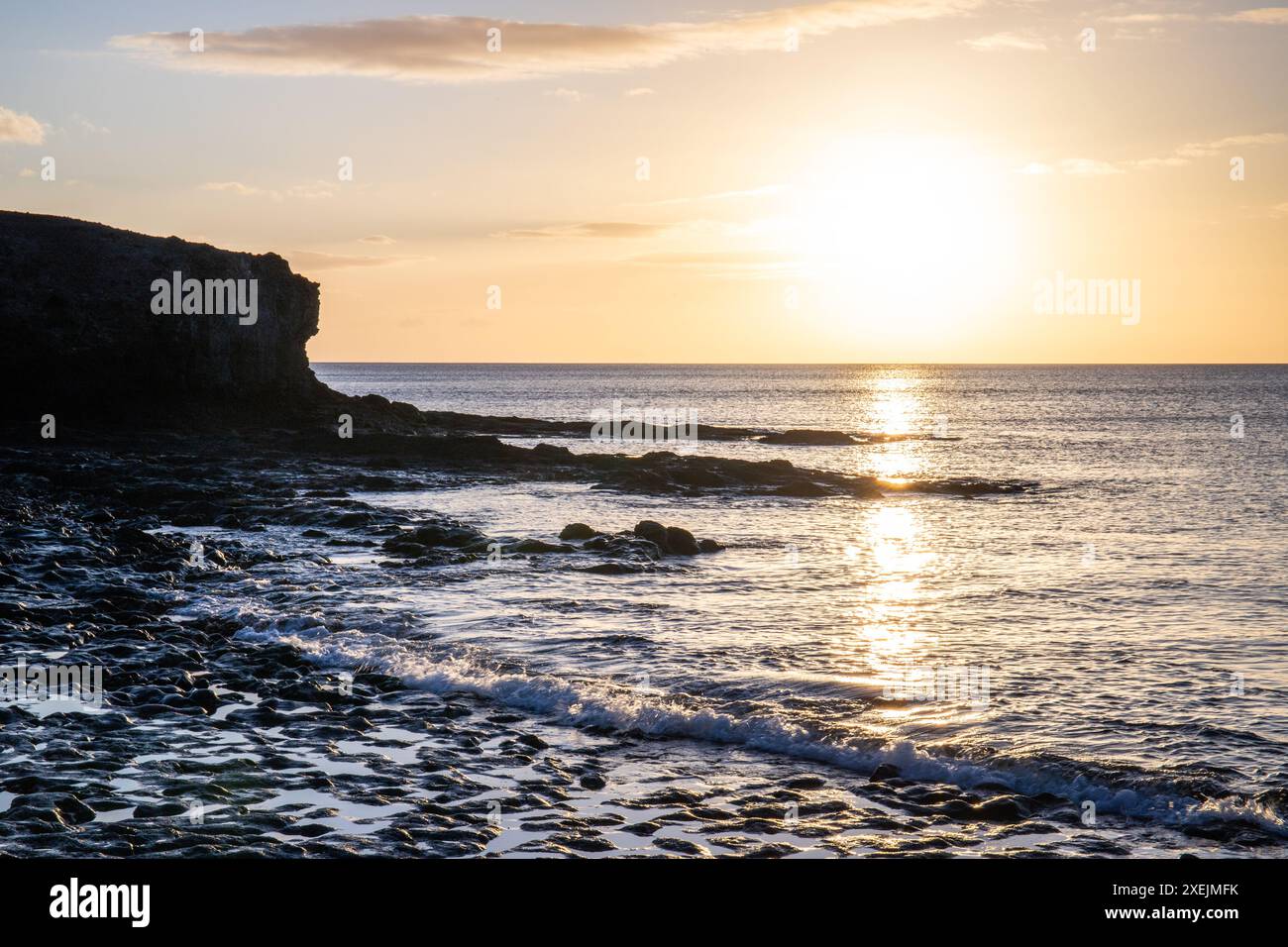 Sonnenaufgang über dem Atlantik. Steinstrand auf einer Vulkaninsel, Fuerteventura, Kanarischen Inseln Stockfoto