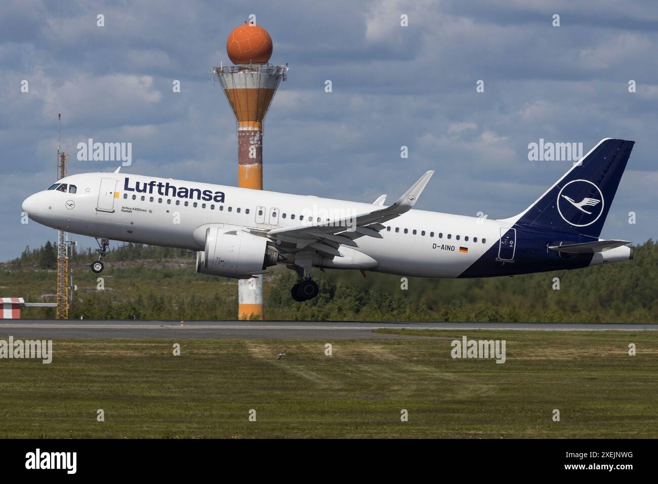 Helsinki, Finnland - 5. Juni 2023: Flughafeninfrastruktur mit Radarturm und Start- und Landebahn mit Lufthansa Airbus A320neo Stockfoto