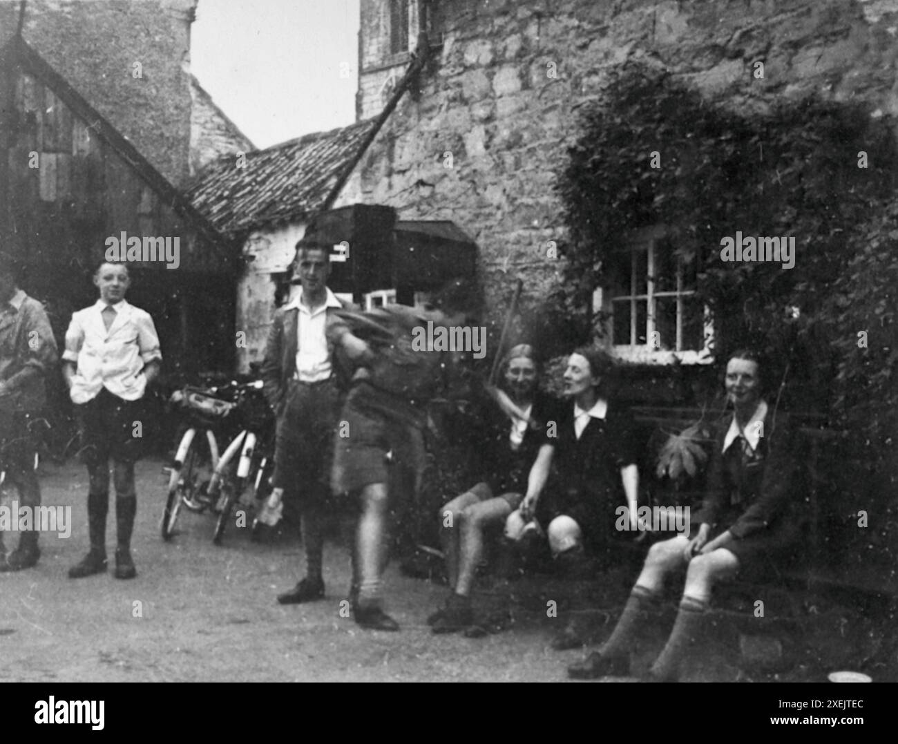 Juni: Eine Gruppe von Radfahrern ruht vor einem Gebäude in Saxton, North Yorkshire. Radtour, 1937. Von einem Album, das eine Fahrradreise durch Großbritannien von einer Gruppe begeisterter Radfahrer umfasste. Das Album wurde von einem Amateurfotografen zusammengestellt und kommentiert und die Tour umfasste North Wales, Yorkshire, Lancashire und Cumbria. Es gab keinen Hinweis darauf, wer das Album komponiert hat. Die Größe der Originalfotos variierte, wobei die kleinsten ca. 3 x 2 Zoll, die größten ca. 7 x 5 Zoll waren. Stockfoto