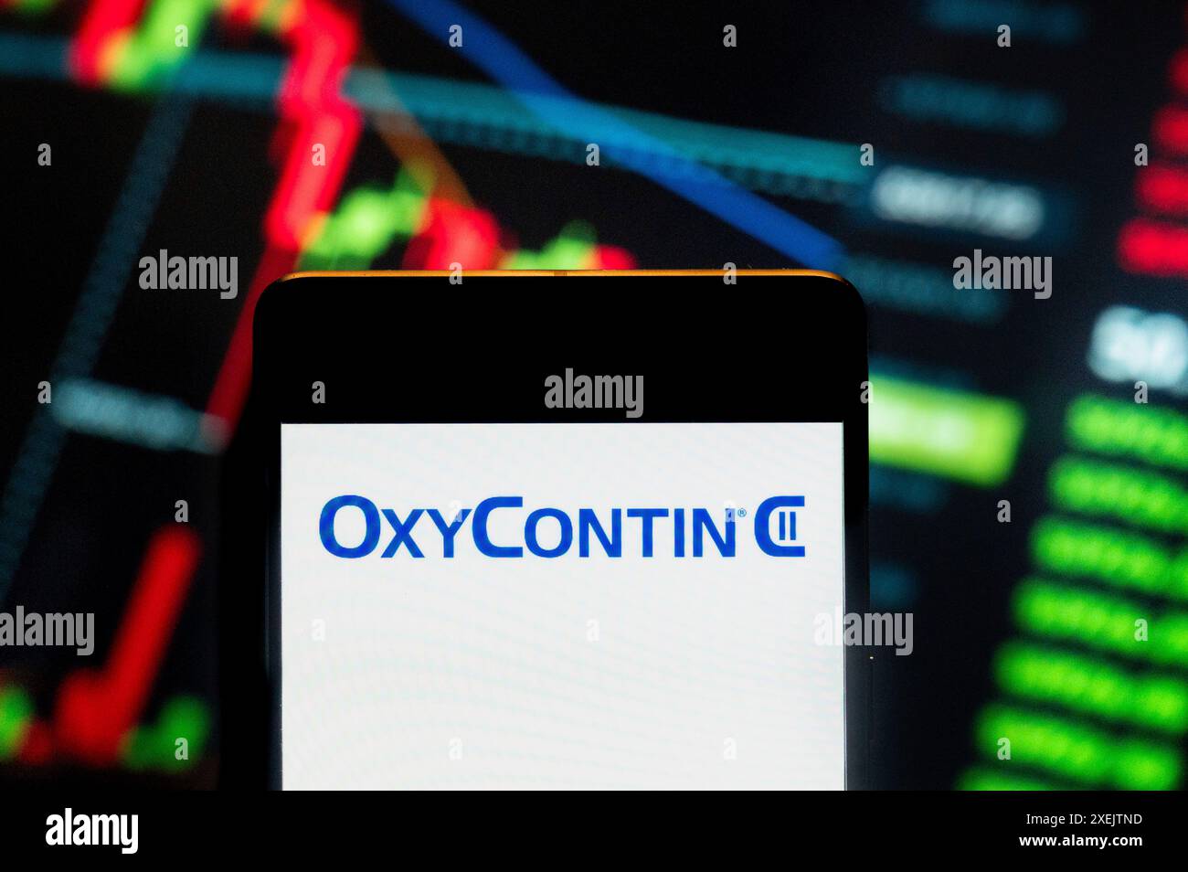 China. Juni 2024. In dieser Fotoabbildung wurde das OxyContin Schmerzmittel-Logo des Pharmaunternehmens der Familie Sackler produziert und glaubte, die Schuld für die Opioidkrise der Vereinigten Staaten, Purdue Pharma, zu sehen auf einem Smartphone mit einem wirtschaftlichen Börsenindex-Diagramm im Hintergrund. Quelle: SOPA Images Limited/Alamy Live News Stockfoto