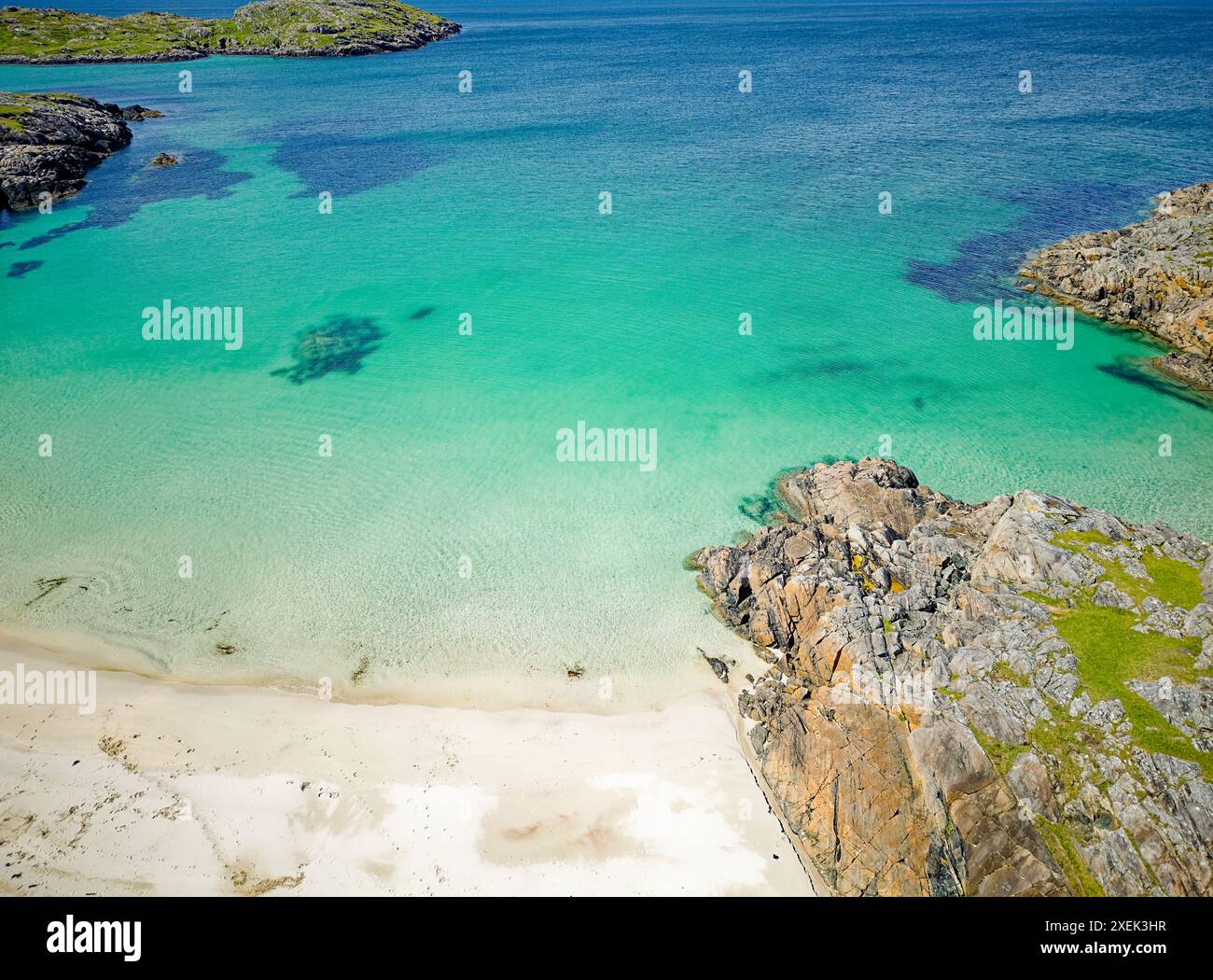 Achmelvich Sutherland Schottland Sonnenschein über dem Strand und blaugrünes Meer mit Felsen von braunem lewischem Gneis Stockfoto