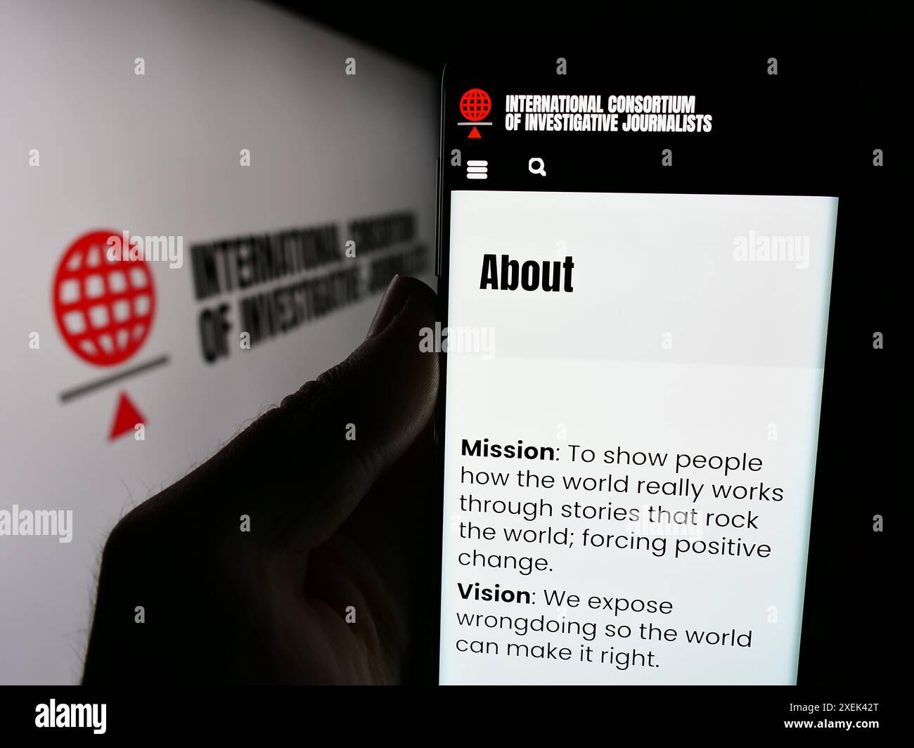 Person, die ein Handy hält, mit Webseite des Internationalen Konsortiums investigativer Journalisten (ICIJ) mit Logo. Konzentrieren Sie sich auf die Mitte des Telefondisplays. Stockfoto