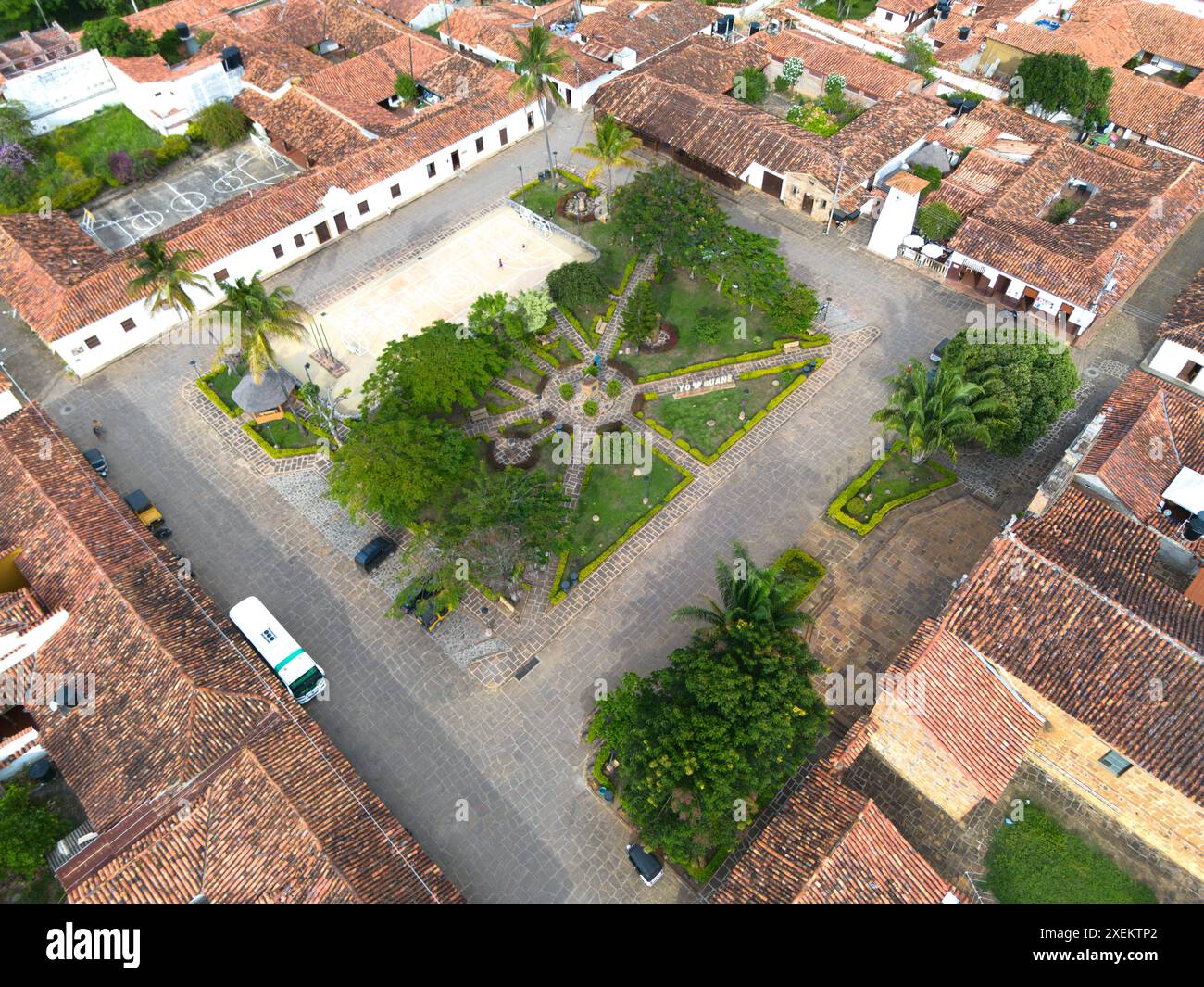 Ein Bild über dem Kopf zeigt den Platz von Guane, Santander, mit seinem symmetrischen Layout von Gärten und historischen Gebäuden mit charakteristischen roten Dächern. Stockfoto