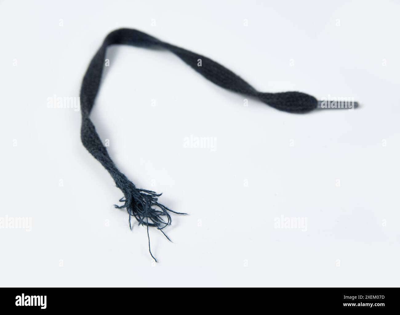 Zerrissene Schnürsenkel auf weißem Hintergrund Stockfoto