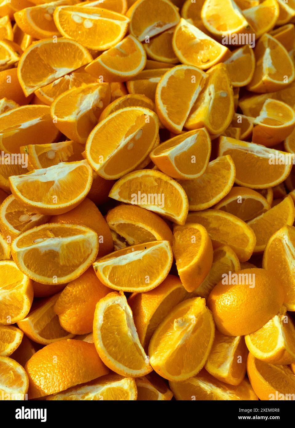Nahansicht von Orangen, die in Segmente geschnitten sind, mit aufziehbarer Schale Stockfoto