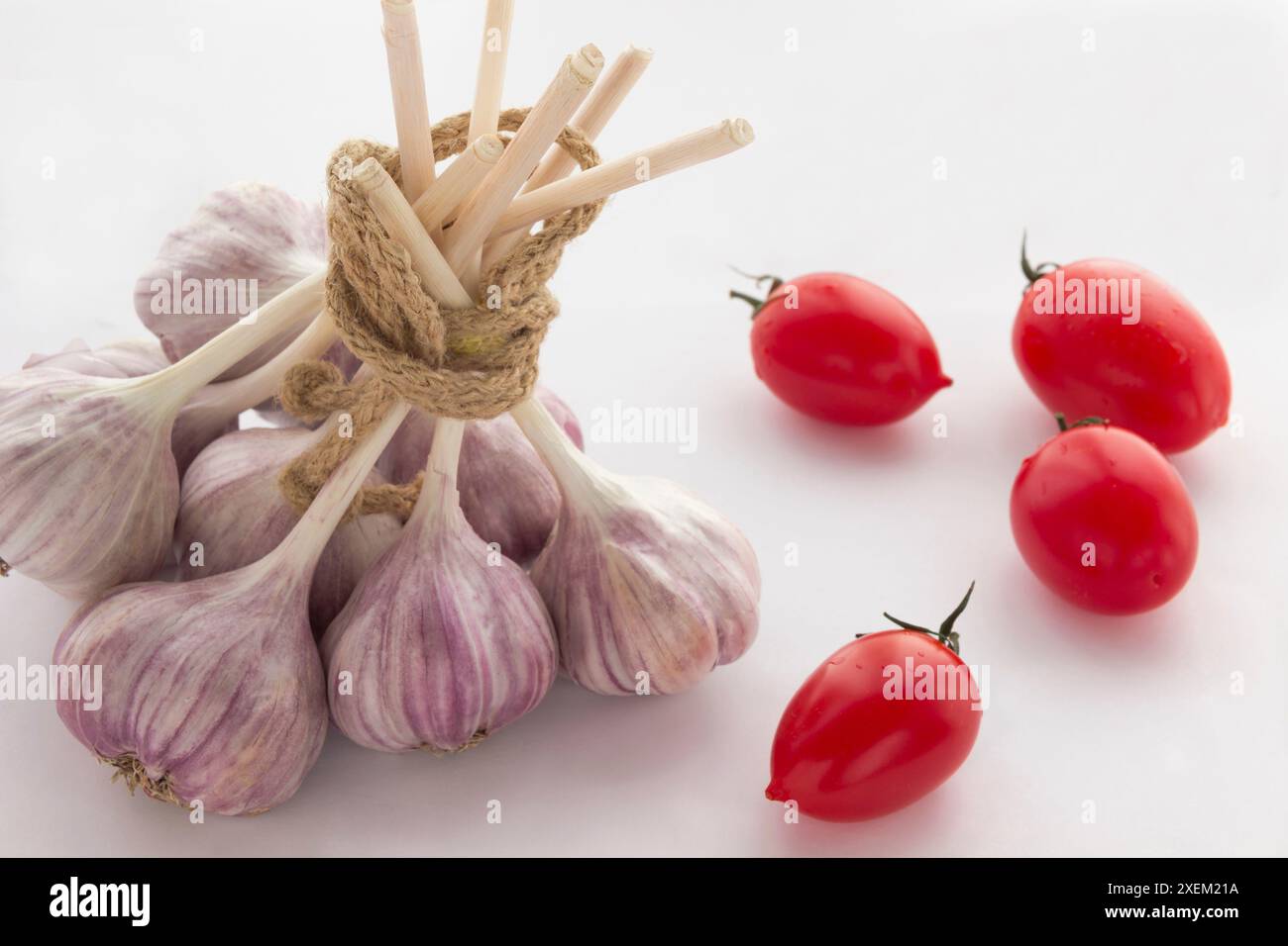 Ein Haufen Knoblauch, rote Tomaten und Pfeffer auf dem Tisch Stockfoto