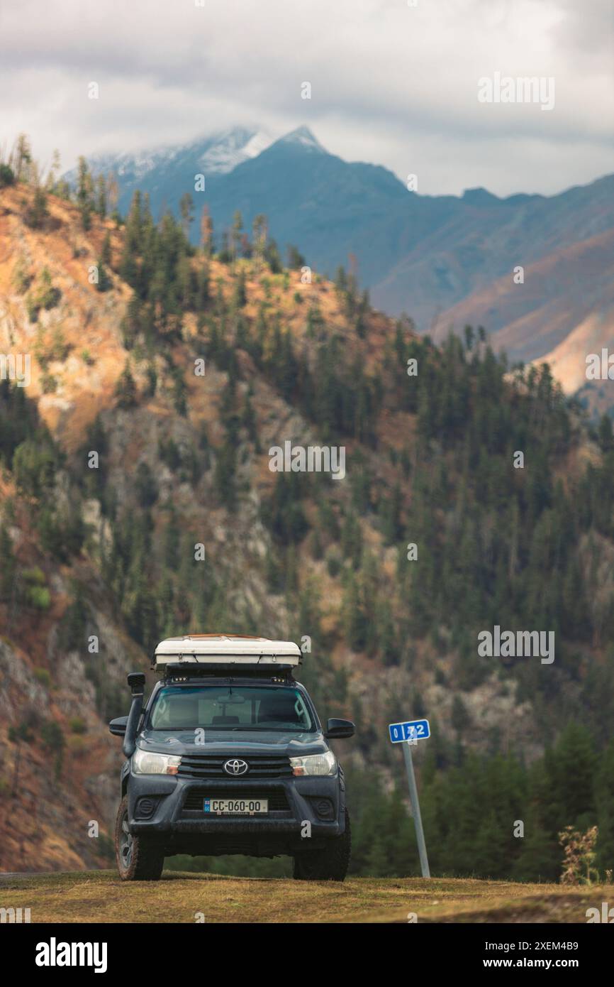 Sportfahrzeug parkt an einer Kilometermarkierung in Omalo im Tusheti-Nationalpark, Georgia; Omalo, Kakheti, Georgia Stockfoto