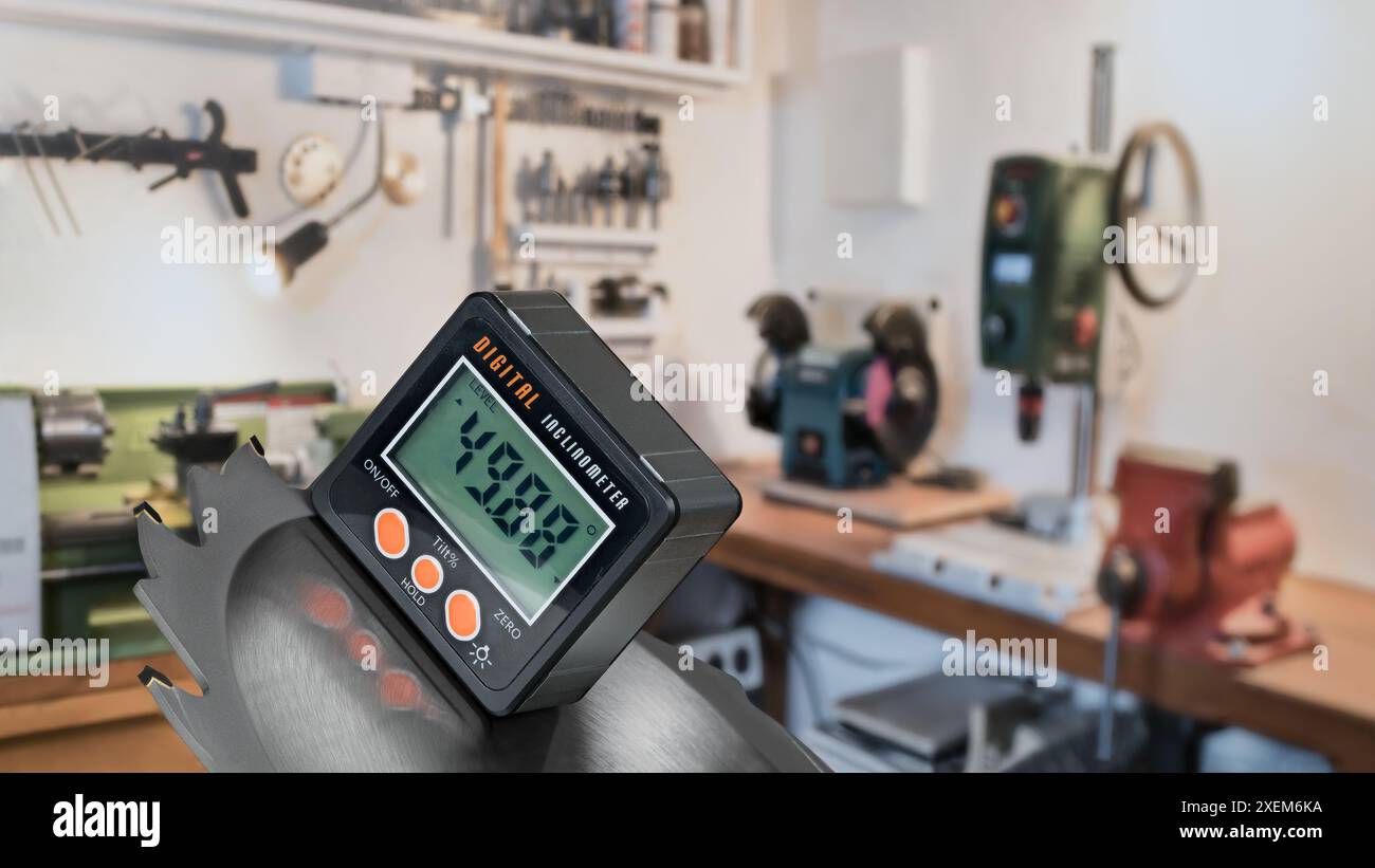 Digitaler Neigungsmesser zur Messung des Neigungswinkels des Kreissägeblattes. Elektronischer Winkelmesser in der Werkstatt. Tischschleifer, HandSchraubstock, Bohrmaschine, Drehmaschine. Stockfoto