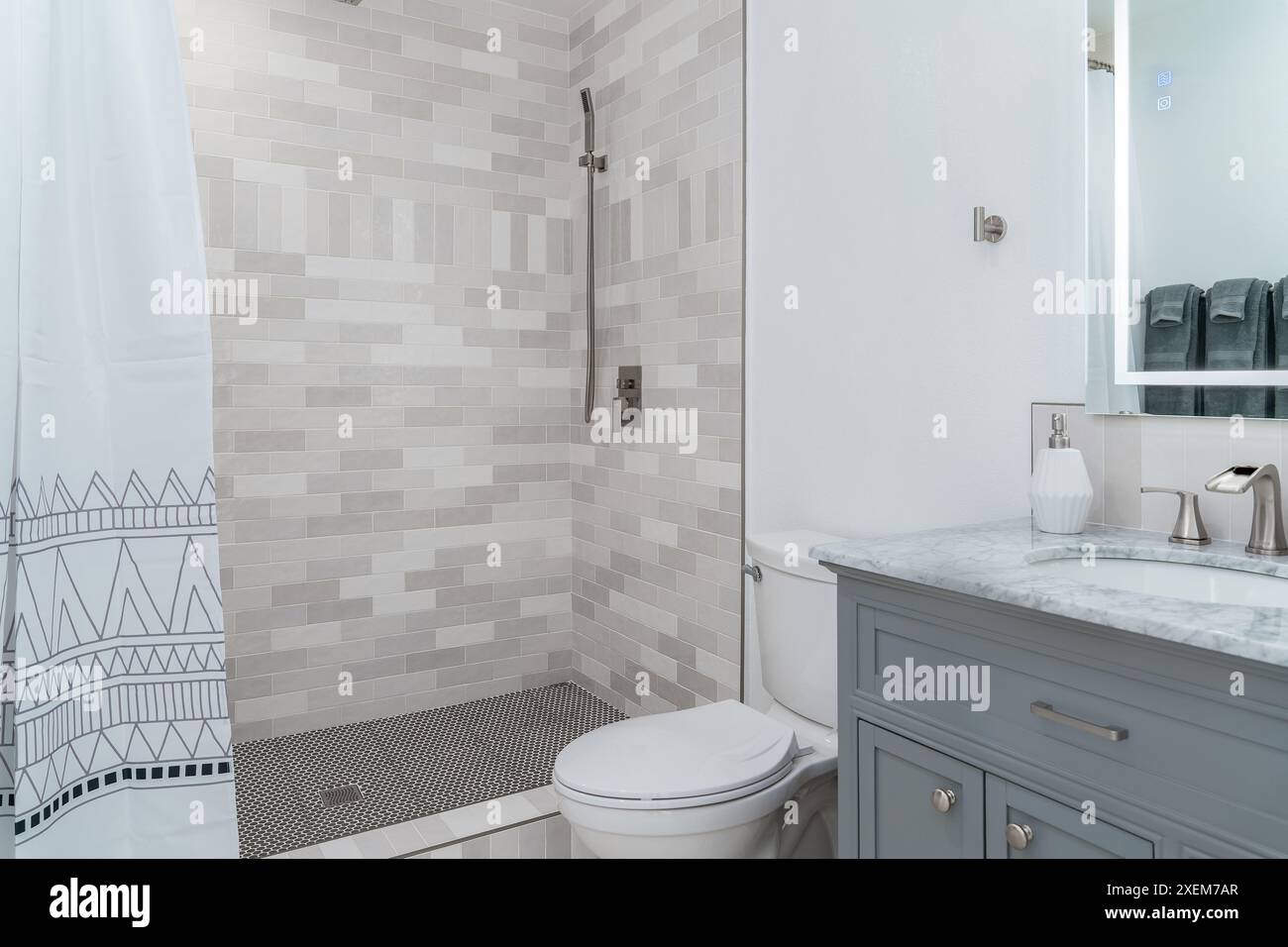 Modernes Bad in weiß mit grauer Dusche, bemalter Holzschrank und Marmorwaschbecken Stockfoto