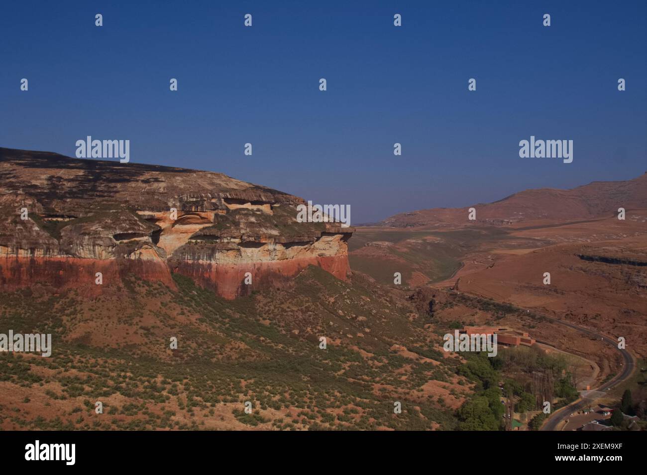 Große hohe Klippe mit Sonnenlicht; Brandwag Buttress beeindruckende Sandsteinformationen Felsenklippe Tal Mountain Golden Gate Highlands National Park Stockfoto