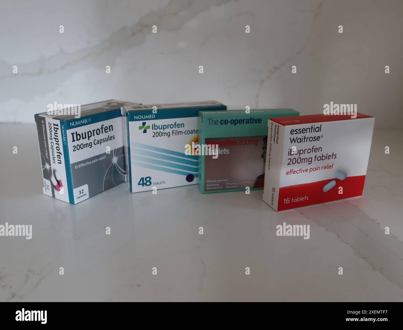 4 Packungen mit verschiedenen Marken von Ibuprofen, einem beliebten nicht-steroidalen entzündungshemmenden, frei verkäuflichen Schmerzmittel aus Apotheken und Supermärkten. Stockfoto