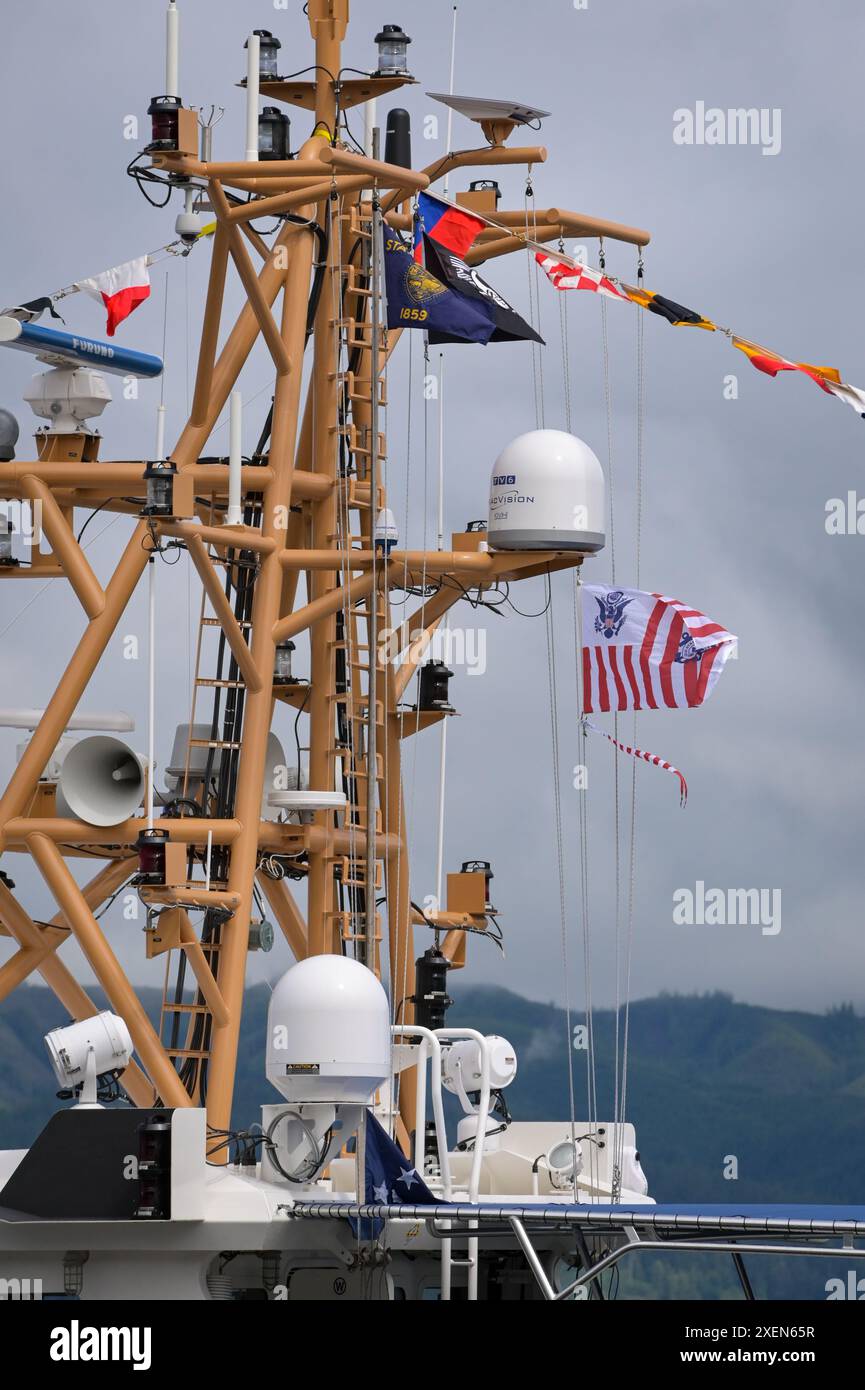 Die Küstenwache und ein Wimpel werden auf dem Mast des Küstenwache Cutter David Duren (WPC 1156) während der Inbetriebnahme des Cutters in Astoria, Ore., am 27. Juni 2024 gehisst. Der David Duren ist ein 154 Fuß langer Fast Response Cutter mit einer durchschnittlichen Besatzungsgruppe von vier Offizieren und 20 Mitgliedern. (Foto der US-Küstenwache von Petty Officer Steve Strohmaier) Stockfoto