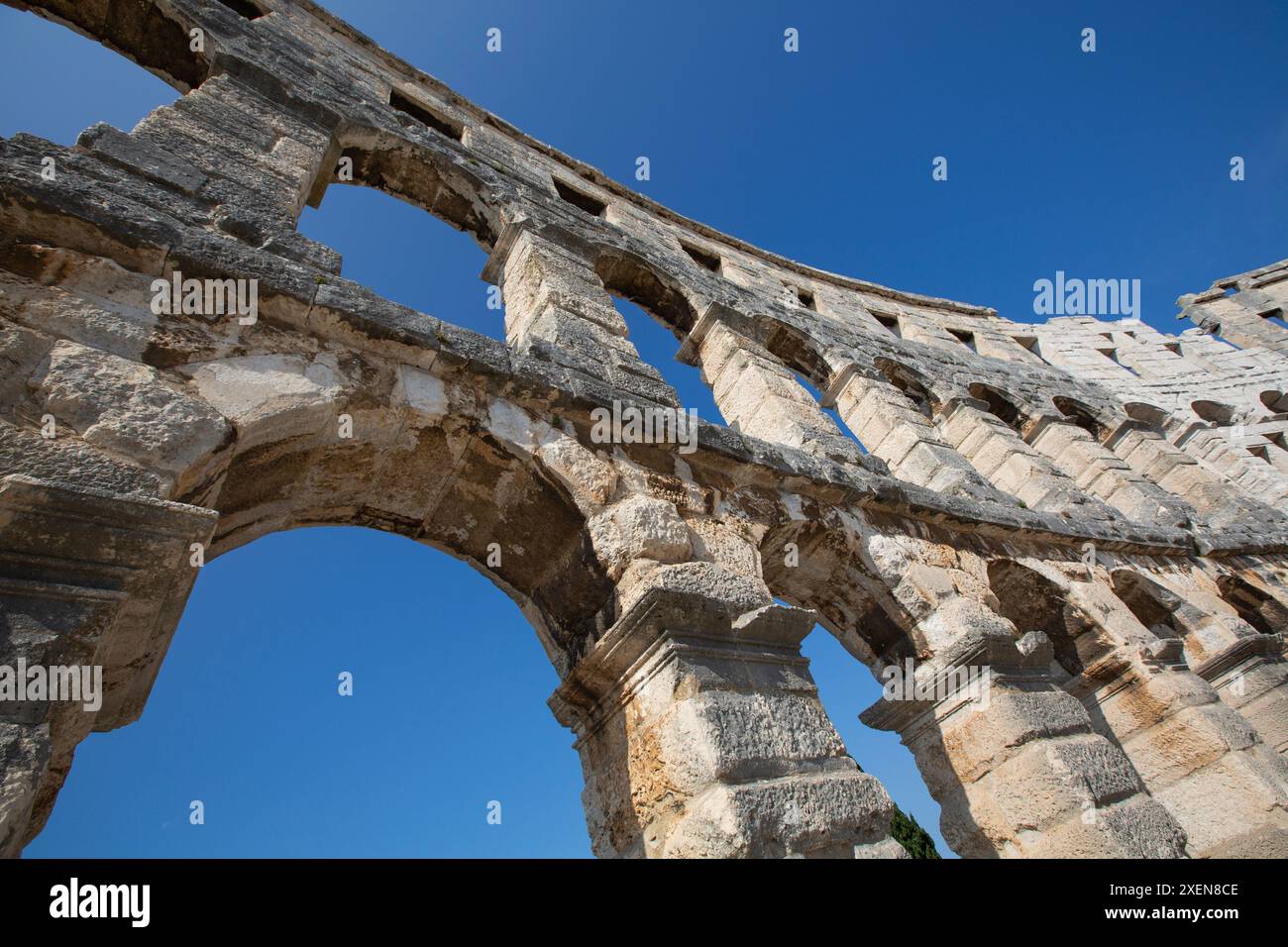 Nahaufnahme eines Abschnitts der Steinstruktur des antiken römischen Amphitheaters, der Pula Arena vor blauem Himmel, erbaut zwischen 27 v. Chr. und 68 n. Chr Stockfoto