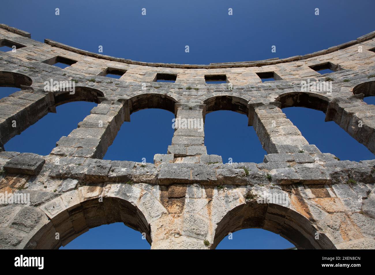 Nahaufnahme eines Abschnitts der Steinstruktur des antiken römischen Amphitheaters, der Pula Arena vor blauem Himmel, erbaut zwischen 27 v. Chr. und 68 n. Chr Stockfoto