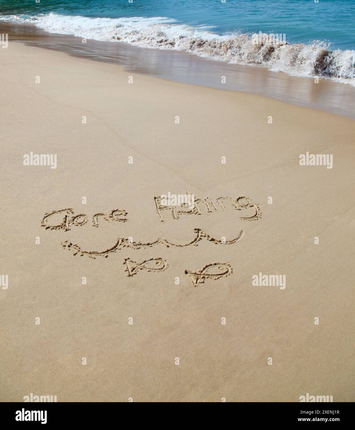 Gehen Sie fischen geschrieben in den Sand am Strand. Urlaubskonzept. Stockfoto