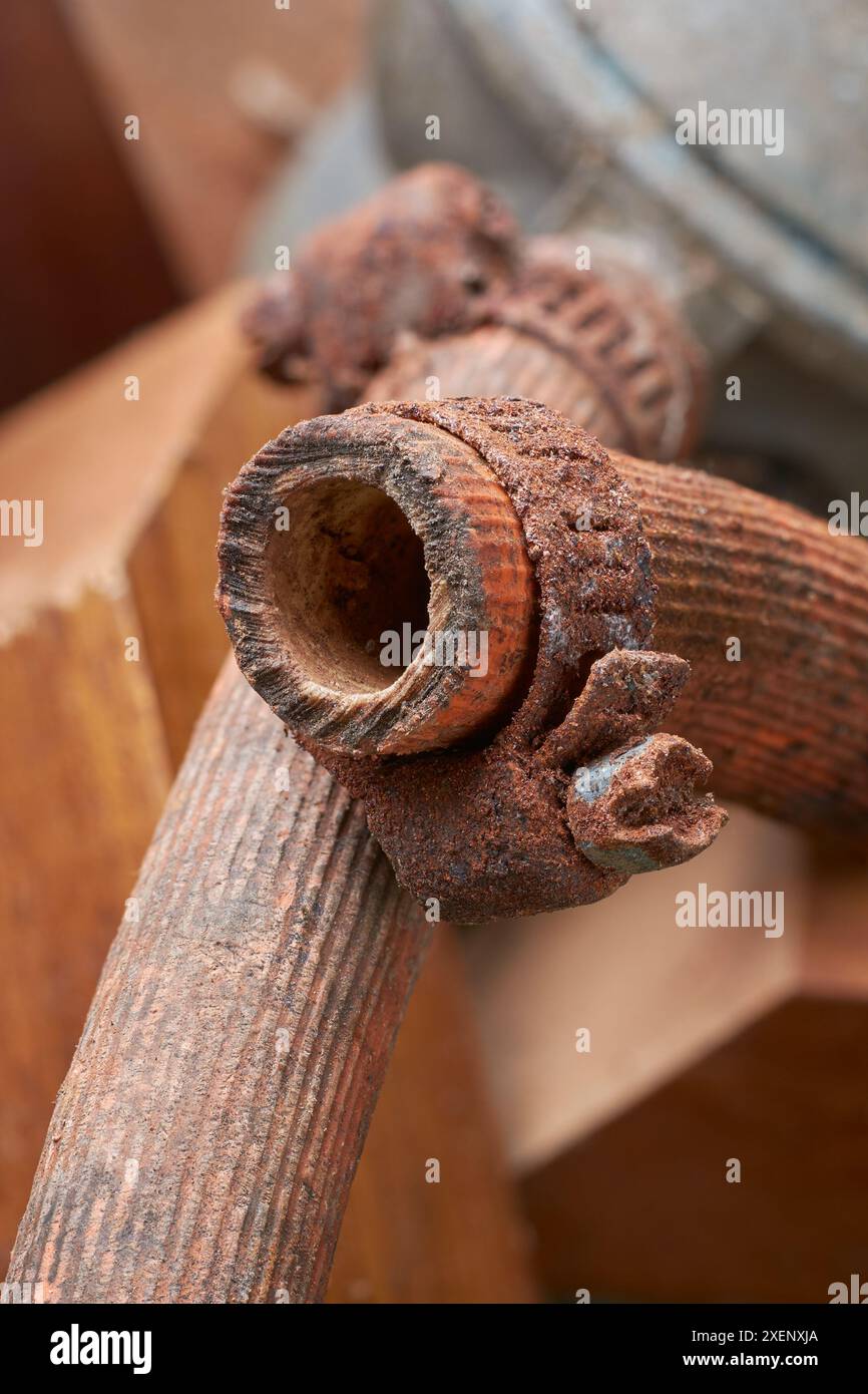 Alte rostige Gummischelle in Nahaufnahme, verwittertes, unbrauchbares Metallband, das in Kfz-, Sanitär-, Gas- oder Gartenarmaturen verwendet wird, längere Exposition Stockfoto