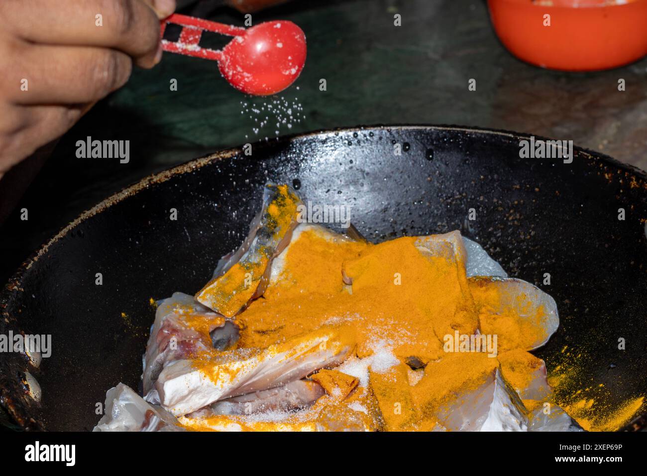 Frische Fischfleischscheiben zum Vorbereiten, Fischkochen Kurkumapulver und Salz Stockfoto