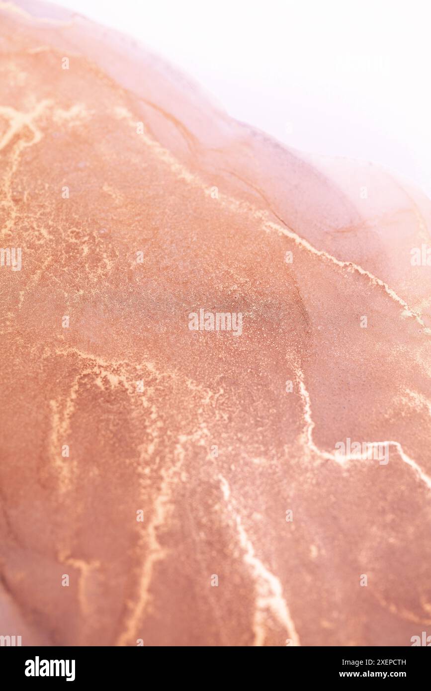 Ein abstraktes Nahbild von wirbelnder Tinte in Roségold- und Grautönen. Die komplizierten Muster schaffen ein einzigartiges und faszinierendes visuelles Erlebnis Stockfoto