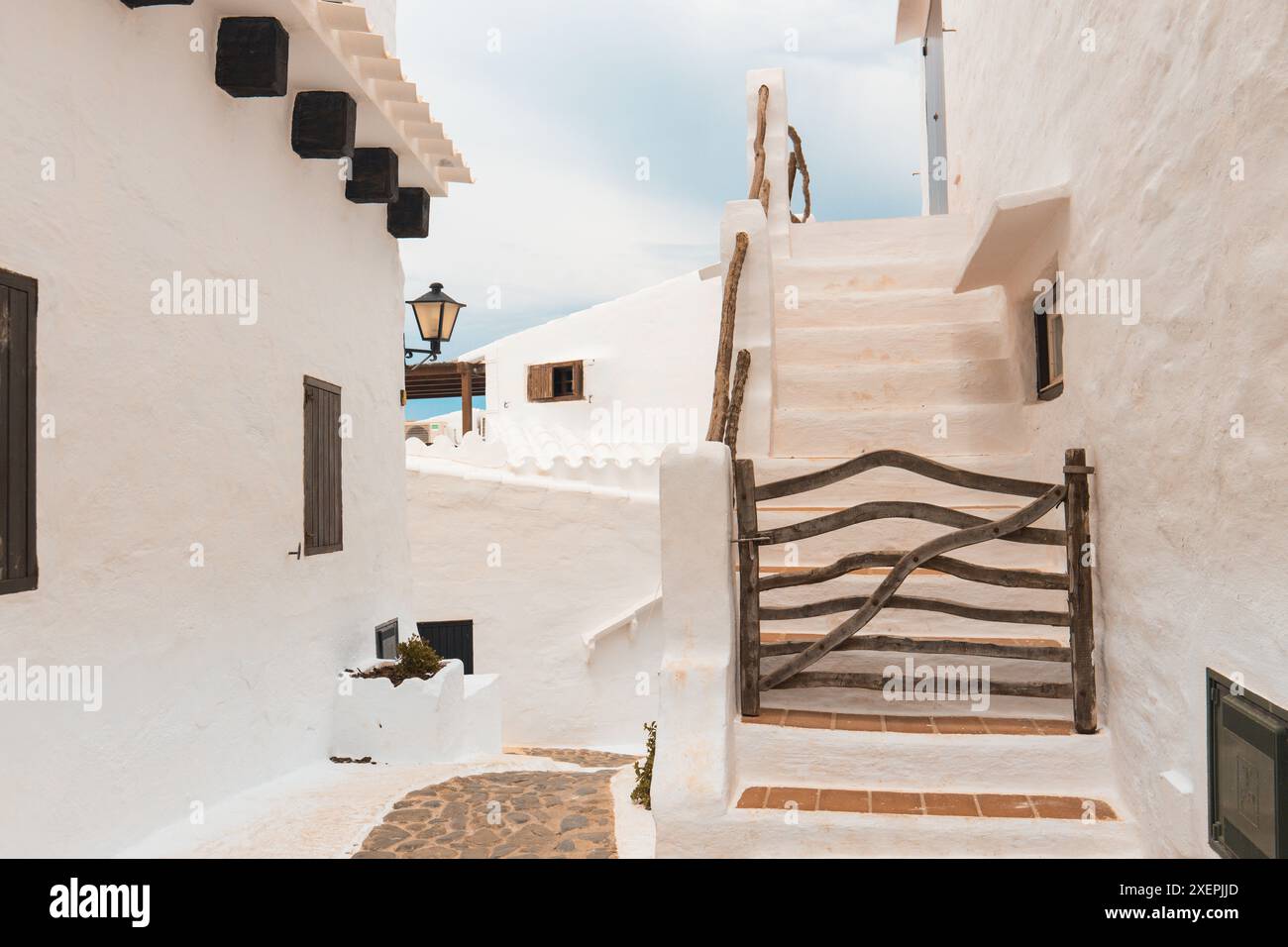 Wunderschönes Spanien. Die charmante Stadt Binibeca auf Menorca. Weiße Wände von Häusern mit Holzelementen Stockfoto