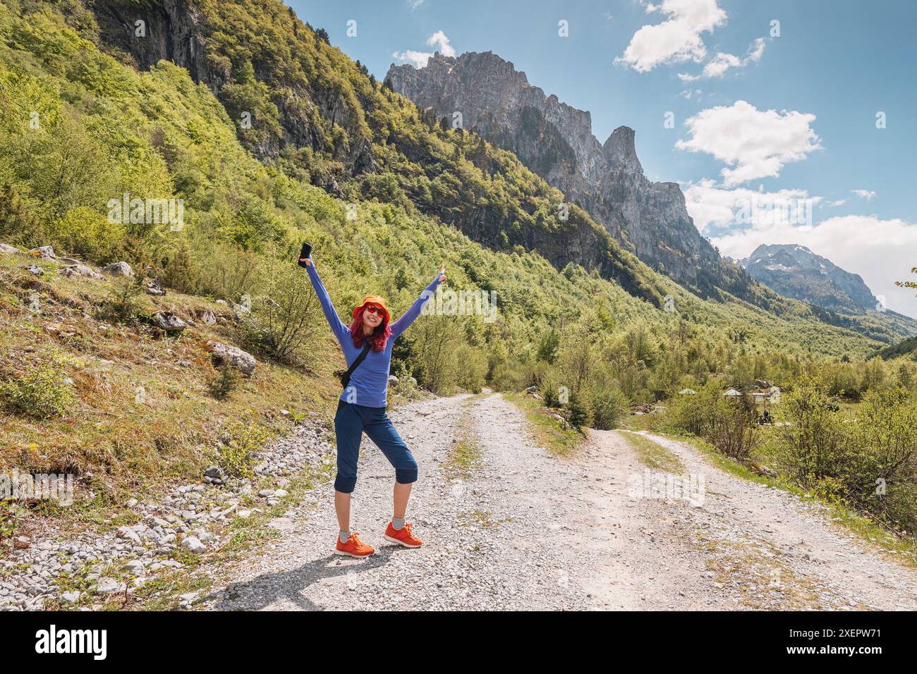 Eine junge Frau wandert im Prokletije-Nationalpark Montenegros, umgeben von majestätischen Bergen und atemberaubenden Landschaften, die die Freiheit der freien Natur genießen Stockfoto