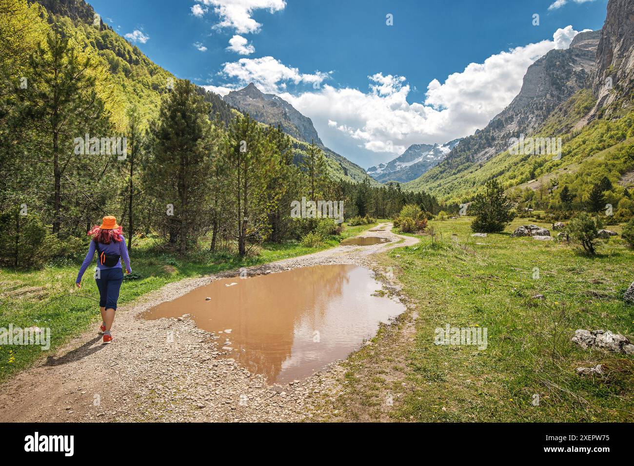 Eine junge Frau wandert im Prokletije-Nationalpark Montenegros, umgeben von majestätischen Bergen und atemberaubenden Landschaften, die die Freiheit der freien Natur genießen Stockfoto