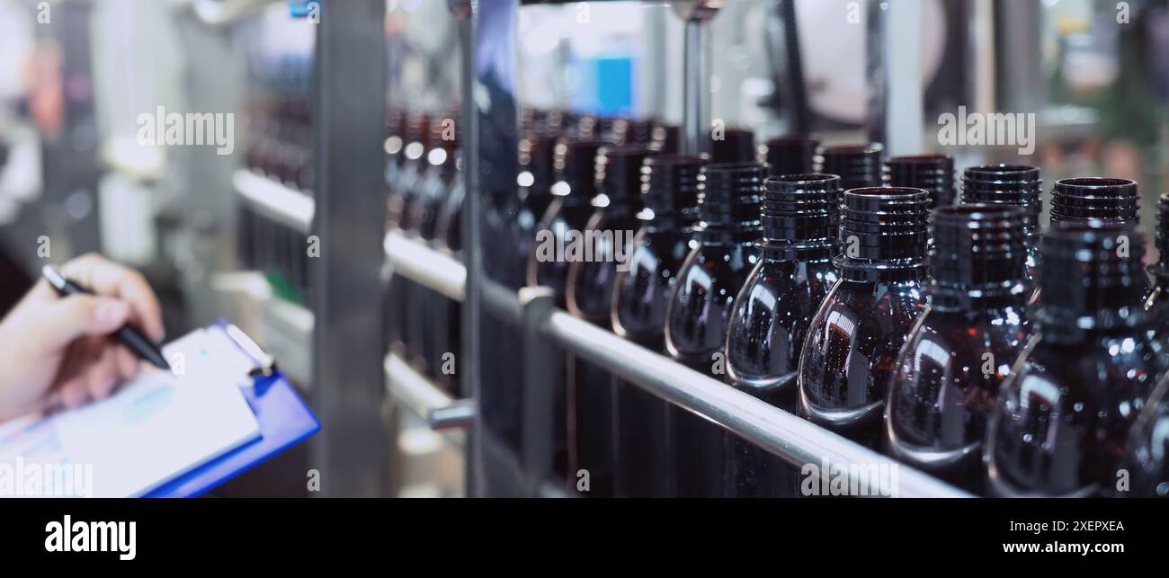 Automationsmaschine für die Flaschenabfüllung in modernen Fabriken. Technologiedemonstration zum Befüllen und Verschließen von Flaschen in der Industrie. Inspektion der Fläschchen für Stockfoto