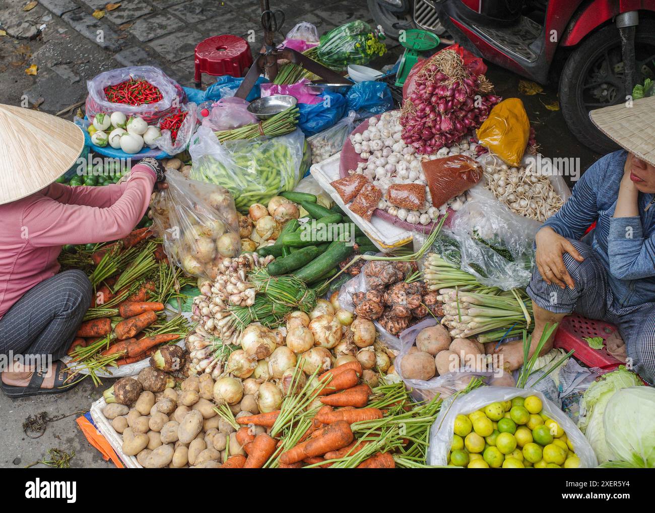 Hoi an, Vietnam - 5. Februar 2024: Obst- und Gemüsehändler mit traditionellen asiatischen konischen Hüten, Hoi an Market, Vietnam Stockfoto