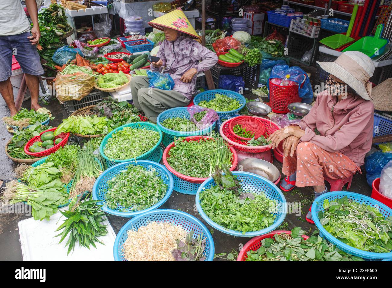 Hoi an, Vietnam - 5. Februar 2024: Obst- und Gemüsehändler mit traditionellen asiatischen konischen Hüten, Hoi an Market, Vietnam Stockfoto