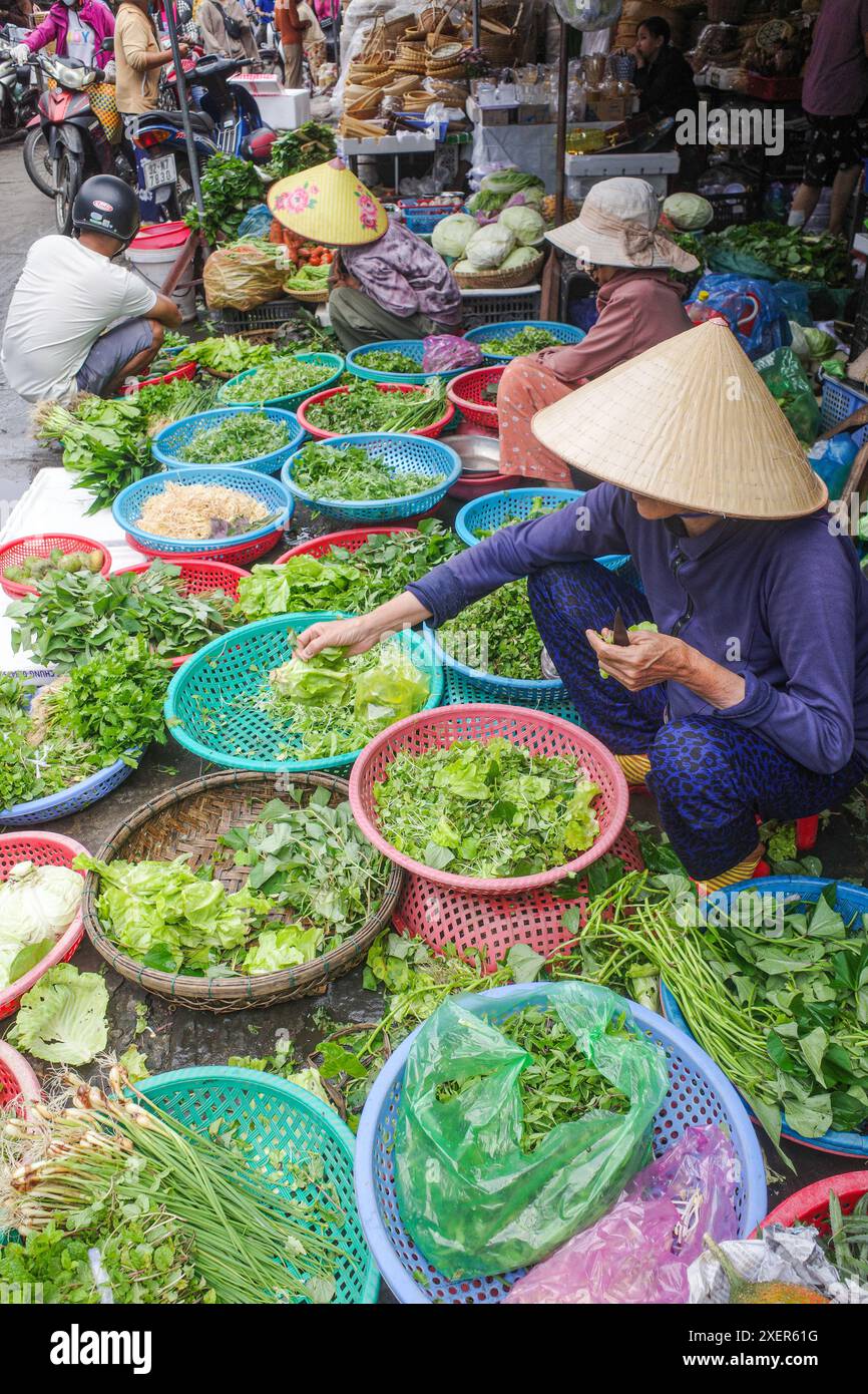 Hoi an, Vietnam - 5. Februar 2024: Obst- und Gemüsehändler mit traditionellen asiatischen konischen Hüten, Hoi an Market, Vietnam Stockfoto