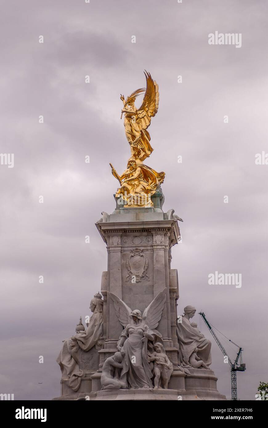 Die goldene Statue des Victoria Memorial in der Nähe des Buckingham Palace in London unter bewölktem Himmel, Symbol der britischen Monarchie und Pracht Stockfoto