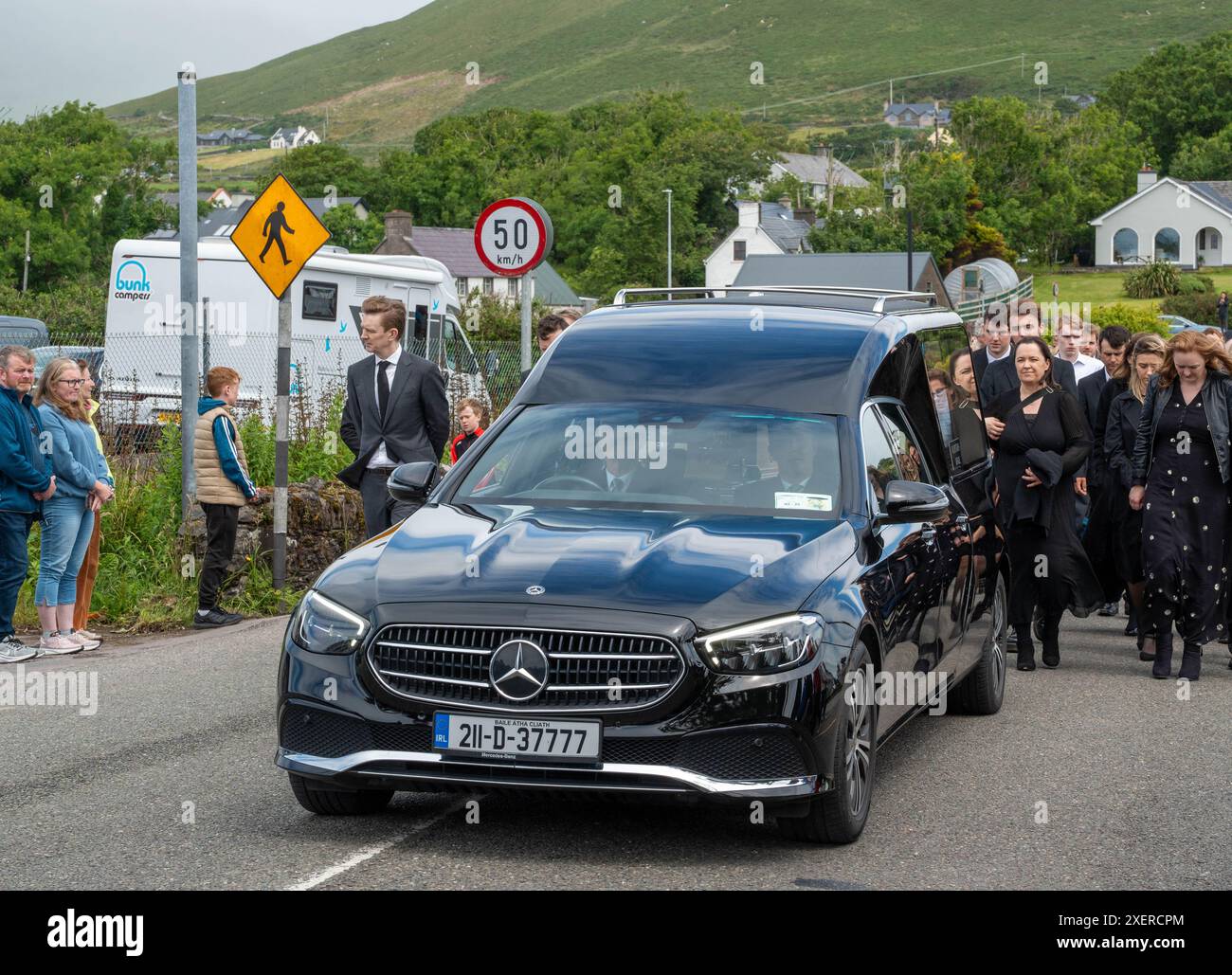 Der Leichenwagen mit dem berühmten Kommentator der gälischen Spiele Micheal O Muircheartaigh macht sich nach seiner Beerdigung in der St. Mary's Church in Dingle, Co Kerry, auf den Weg zu seinem Buriel-Platz. Herr O Muircheartaigh starb am Dienstagmorgen im Alter von 93 Jahren in einem Krankenhaus in Dublin, umgeben von Familienmitgliedern. Die Stimme des ehemaligen RTE-Senders von Co Kerry wurde während einer jahrzehntelangen Karriere zum Synonym für die GAA in Irland. Bilddatum: Samstag, 29. Juni 2024. Stockfoto