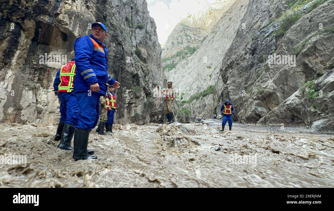 Bischkek, Kirgisistan. Juni 2024. Rettungskräfte arbeiten am 28. Juni 2024 an der Stelle eines Schlammstroms in der Region Nookat in der Oblast Osh in Kirgisistan. Fünf Menschen sind infolge eines Schlammstroms im Süden Kirgisistans ums Leben gekommen, berichtete der Pressedienst des Ministeriums für Notsituationen des Landes am Samstag. Starke Regenfälle in der Region Nookat in der Osh Oblast am Freitag lösten Schlammströme aus, die zwei Brücken und Strommasten beschädigten und 15 Innenhöfe von Privathäusern überschwemmten. Quelle: Roman Gainanov/Xinhua/Alamy Live News Stockfoto