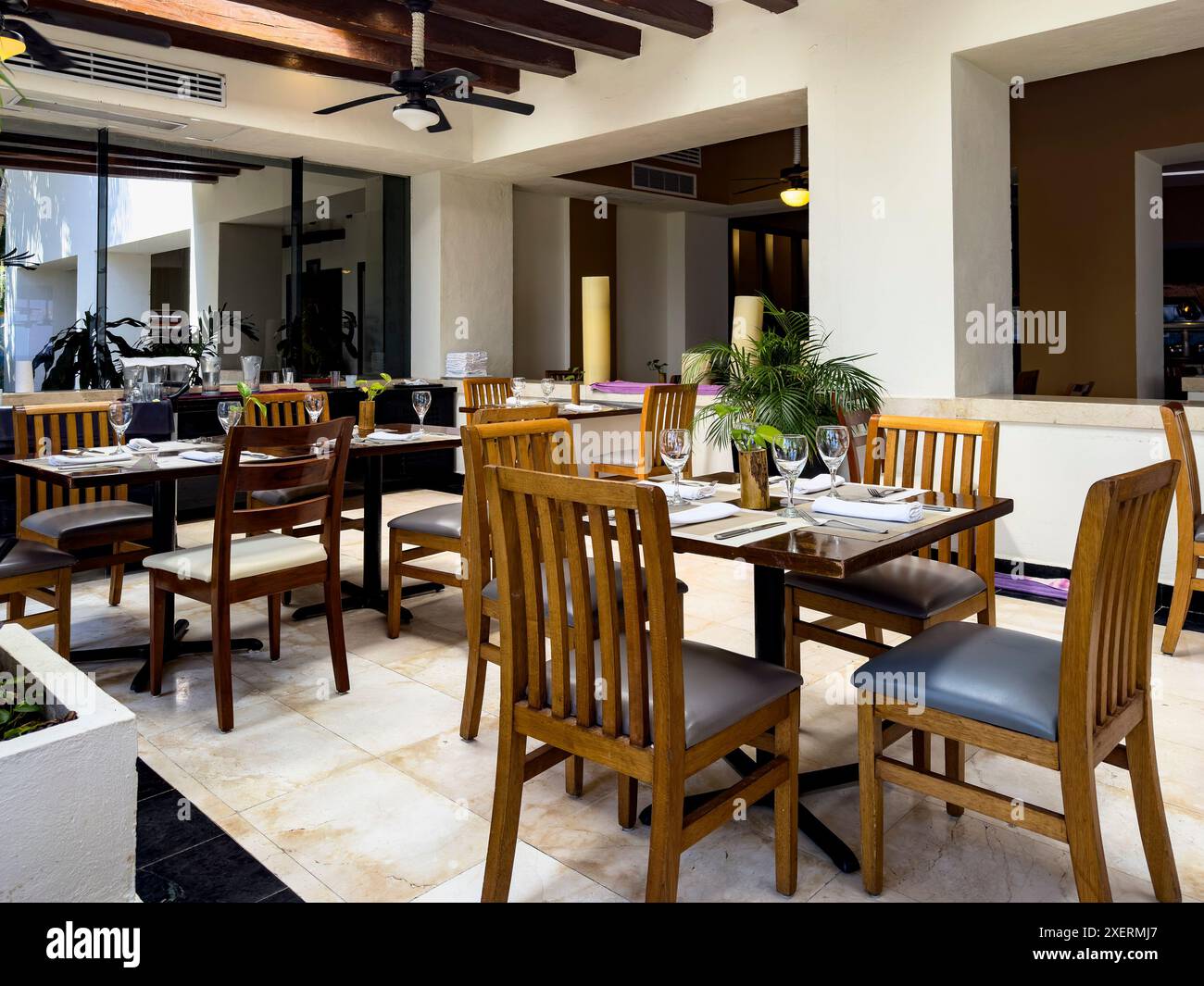 Esstisch im Speisesaal eines luxuriösen karibischen Resorthotels, diese Tische sind in einer karibischen Umgebung mit üppiger tropischer Vegetation und der Stockfoto