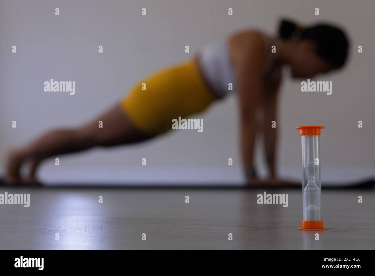 Nahaufnahme von Sanduhr und verschwommener Frau in Plankenstellung Stockfoto