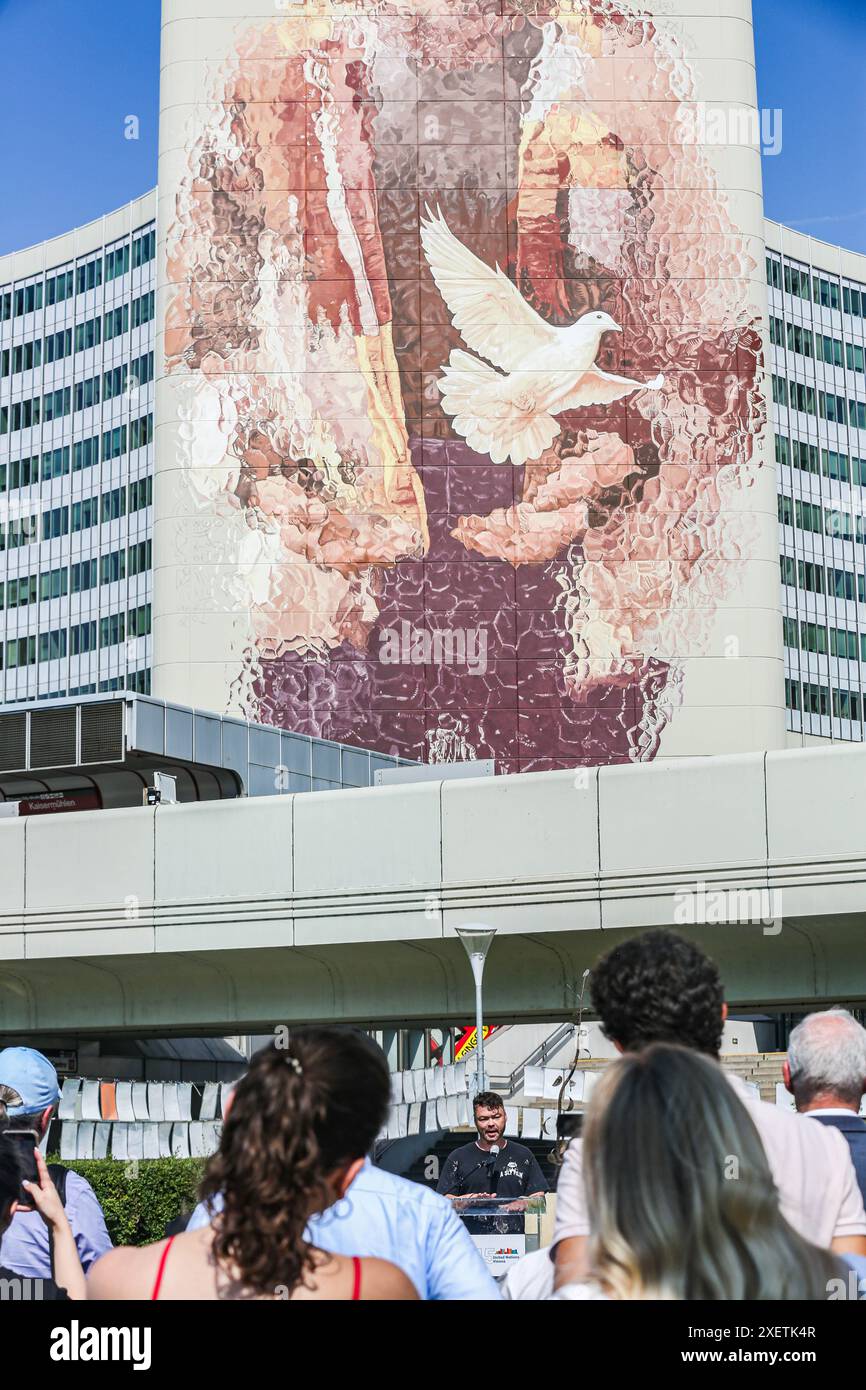 Wien, Österreich, Österreich. Juni 2024. FINTAN MAGEE spricht bei der Enthüllungszeremonie sein eigenes Wandbild - Frau mit Taube - Shaping Our Common Future - gemalt auf dem Südturm der Vereinten Nationen in Wien. Es ist mit 50 Metern Höhe und 20 Metern Breite das größte Wandgemälde Wiens. Auf einem Teil der U-Bahn-Linie können Tausende von Einheimischen und Besuchern das Wandbild vom Zug aus oder einen Besuch im Zentrum sehen. (Kreditbild: © Bianca Otero/ZUMA Press Wire) NUR REDAKTIONELLE VERWENDUNG! Nicht für kommerzielle ZWECKE! Stockfoto