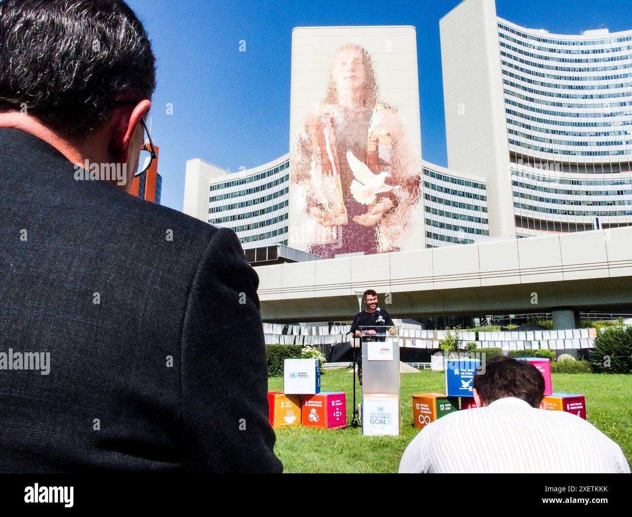 Wien, Österreich, Österreich. Juni 2024. FINTAN MAGEE spricht bei der Enthüllungszeremonie sein eigenes Wandbild - Frau mit Taube - Shaping Our Common Future - gemalt auf dem Südturm der Vereinten Nationen in Wien. Es ist mit 50 Metern Höhe und 20 Metern Breite das größte Wandgemälde Wiens. Der Titel bezieht sich auf die Nachhaltigkeitsziele. Auf einem Teil der U-Bahn-Linie können Tausende von Einheimischen und Besuchern das Wandbild vom Zug aus oder einen Besuch im Zentrum sehen. (Kreditbild: © Bianca Otero/ZUMA Press Wire) NUR REDAKTIONELLE VERWENDUNG! Nicht für kommerzielle ZWECKE! Stockfoto