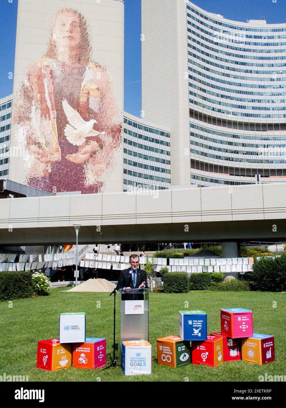 Wien, Österreich, Österreich. Juni 2024. IAN BIGS, Botschafter Australiens in Österreich, spricht bei der Enthüllung von FINTAN MAGEES Wandbild Frau mit Taube - Shaping Our Common Future auf dem Südturm der Vereinten Nationen in Wien. Es ist mit 50 Metern Höhe und 20 Metern Breite das größte Wandgemälde Wiens. Auf einem Teil der U-Bahn-Linie können Tausende von Einheimischen und Besuchern das Wandbild vom Zug aus oder einen Besuch im Zentrum sehen. (Kreditbild: © Bianca Otero/ZUMA Press Wire) NUR REDAKTIONELLE VERWENDUNG! Nicht für kommerzielle ZWECKE! Stockfoto