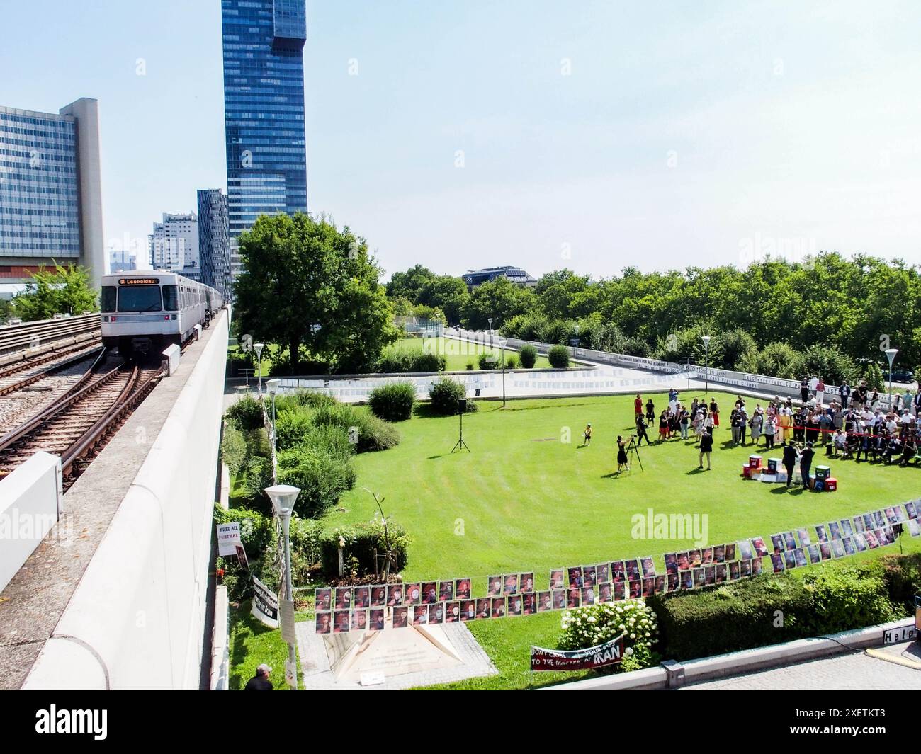 Wien, Österreich, Österreich. Juni 2024. Ein Blick auf das Gelände und die U-Bahn, die vor UNOV vorbeifährt, bei der Enthüllungszeremonie von FINTAN MAGEES Wandgemälde Frau mit Taube - Shaping Our Common Future auf dem Südturm der Vereinten Nationen in Wien. Es ist mit 50 Metern Höhe und 20 Metern Breite das größte Wandgemälde Wiens. Auf einem Teil der U-Bahn-Linie können Tausende von Einheimischen und Besuchern das Wandbild vom Zug aus oder einen Besuch im Zentrum sehen. (Kreditbild: © Bianca Otero/ZUMA Press Wire) NUR REDAKTIONELLE VERWENDUNG! Nicht für kommerzielle ZWECKE! Stockfoto