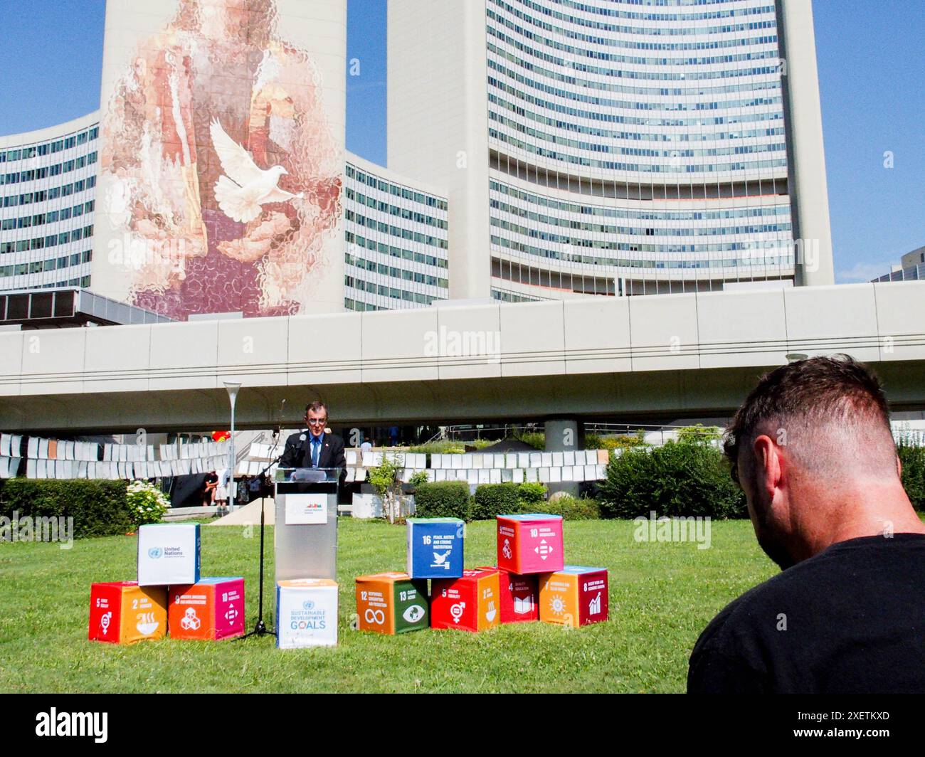 Wien, Österreich, Österreich. Juni 2024. IAN BIGS, Botschafter von Australien in Österreich, spricht mit FINTAN MAGEE, der bei der Enthüllungszeremonie von MAGEES Wandbild Frau mit Taube - Shaping Our Common Future auf dem Südturm der Vereinten Nationen in Wien sitzt. Es ist mit 50 Metern Höhe und 20 Metern Breite das größte Wandgemälde Wiens. Auf einem Teil der U-Bahn-Linie können Tausende von Einheimischen und Besuchern das Wandbild vom Zug aus oder einen Besuch im Zentrum sehen. (Kreditbild: © Bianca Otero/ZUMA Press Wire) NUR REDAKTIONELLE VERWENDUNG! Nicht für kommerzielle ZWECKE! Stockfoto