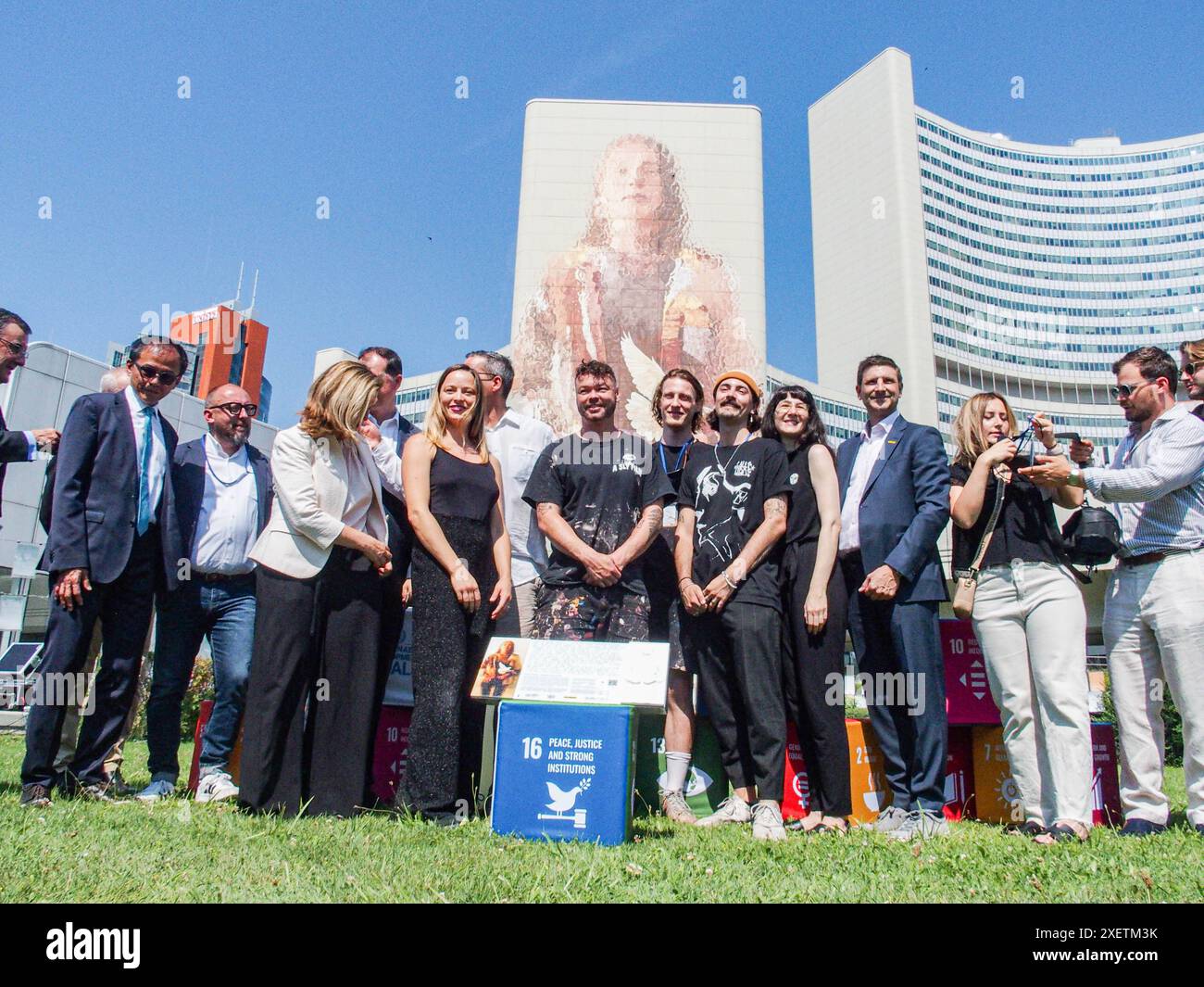 Wien, Österreich, Österreich. Juni 2024. FINTAN MAGEE steht mit Beitragenden, Unterstützern und Mitgliedern der Vereinten Nationen bei der Enthüllungszeremonie von MAGEES Wandgemälde Frau mit Taube - Shaping Our Common Future auf dem Südturm der Vereinten Nationen in Wien. Es ist mit 50 Metern Höhe und 20 Metern Breite das größte Wandgemälde Wiens. Auf einem Teil der U-Bahn-Linie können Tausende von Einheimischen und Besuchern das Wandbild vom Zug aus oder einen Besuch im Zentrum sehen. (Kreditbild: © Bianca Otero/ZUMA Press Wire) NUR REDAKTIONELLE VERWENDUNG! Nicht für kommerzielle ZWECKE! Stockfoto