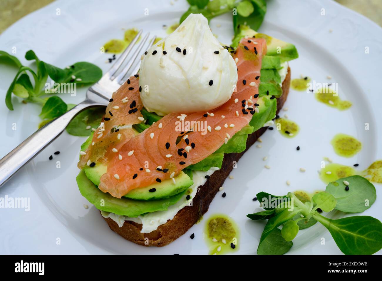 Sandwich mit pochiertem Ei, Avocado und rustikalem Brot für ein elegantes und modernes Frühstück oder Brunch Stockfoto