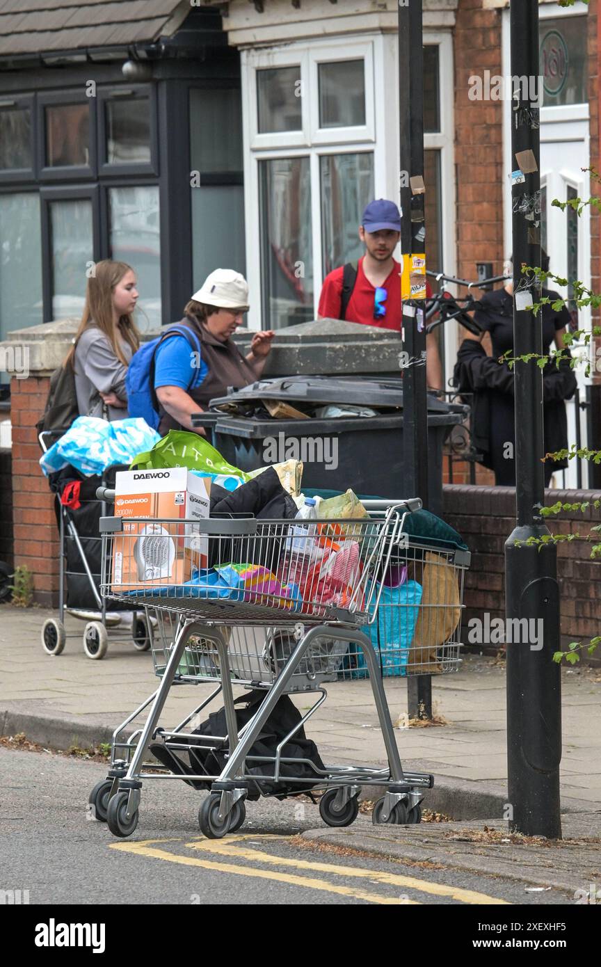 Selly Oak, Birmingham, 30. Juni 2024 - einige Leute wurden entdeckt, um unerwünschte Gegenstände anderer Leute zur Wiederverwendung zu sammeln. - Die Wohnstraßen in Birmingham wurden zu Mülldeponien gemacht, während die Studenten am Ende ihrer Verträge ihr Haus ziehen. Die meisten Studenten besuchen die University of Birmingham, die etwa eine halbe Meile (800 m) von den terrassenförmig angelegten Wohnstraßen von Selly Oak entfernt liegt. Die Straßen wurden hauptsächlich von Vermietern aufgekauft, die sie an die Studenten vermieten, mit einer Reihe von „for Rent“-Schildern. Quelle: Stop Press Media/Alamy Live News Stockfoto